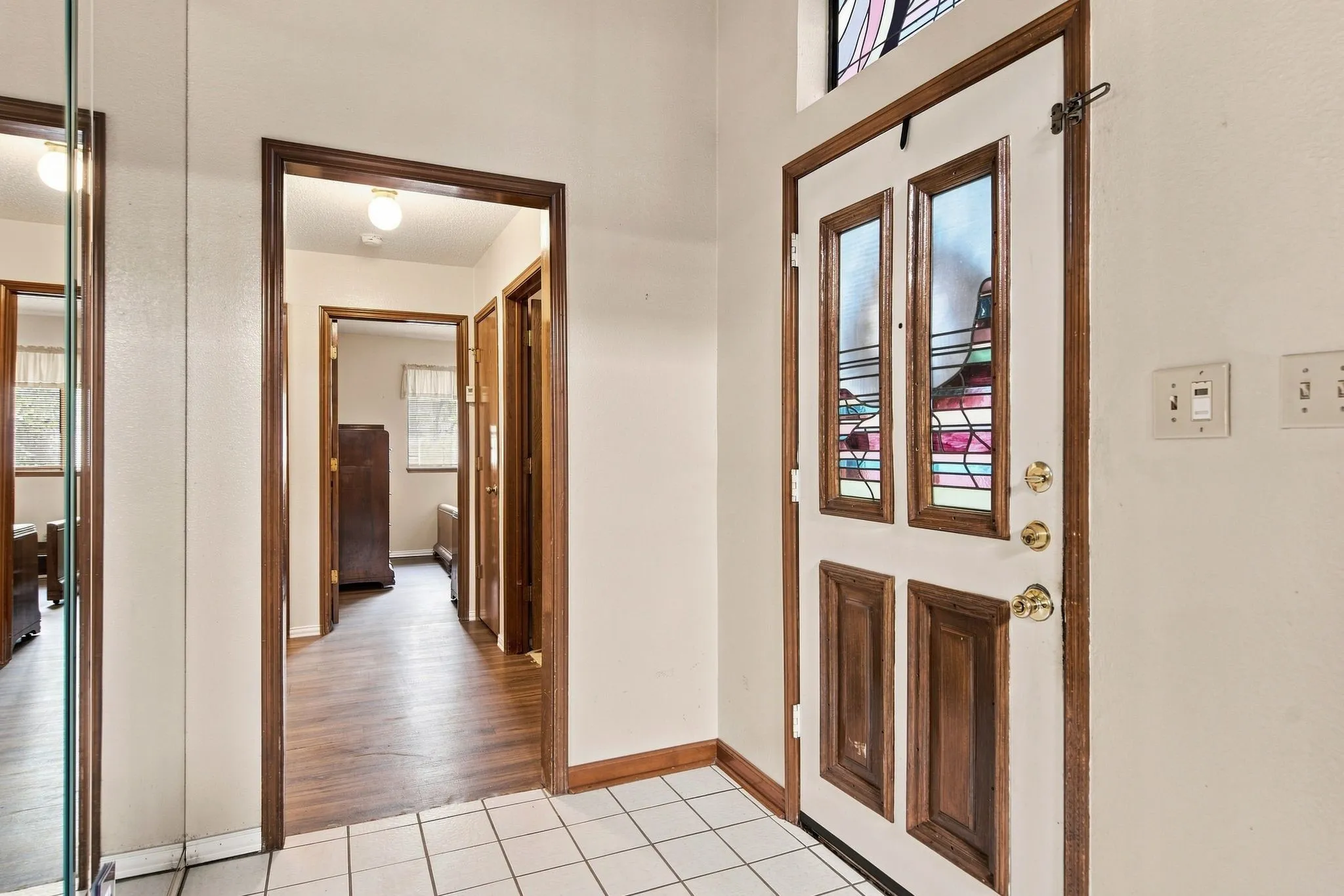 Entryway featuring a white paneled door with glass inserts and stained glass transom
