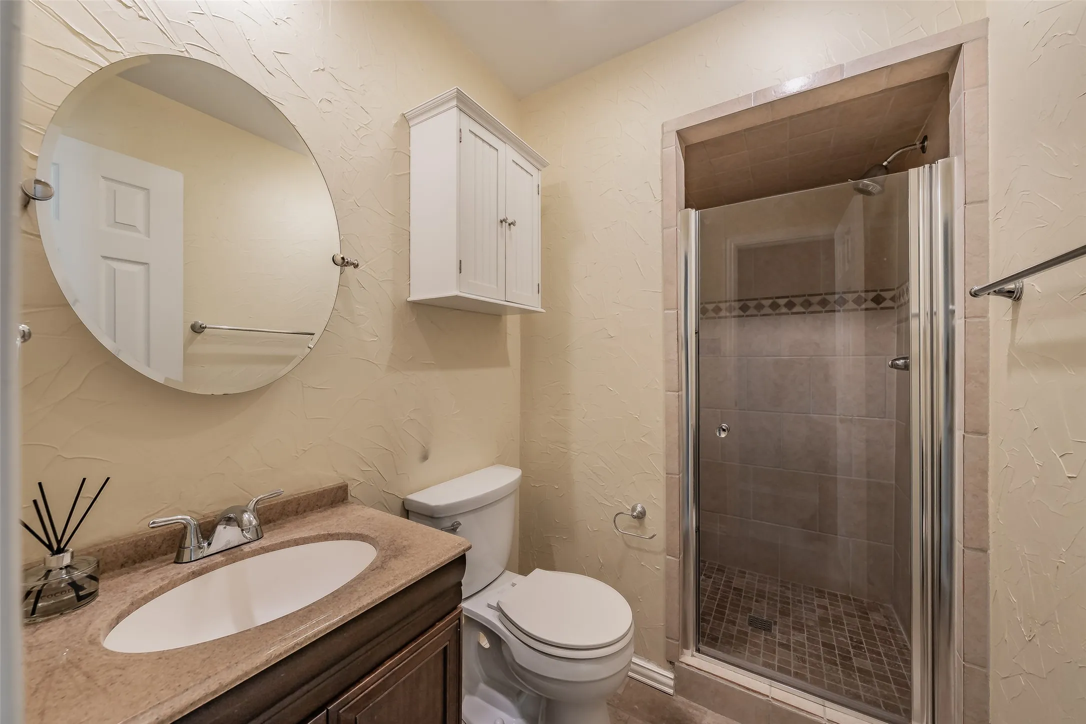 Bathroom with a vanity featuring an oval sink and a stone-finish countertop