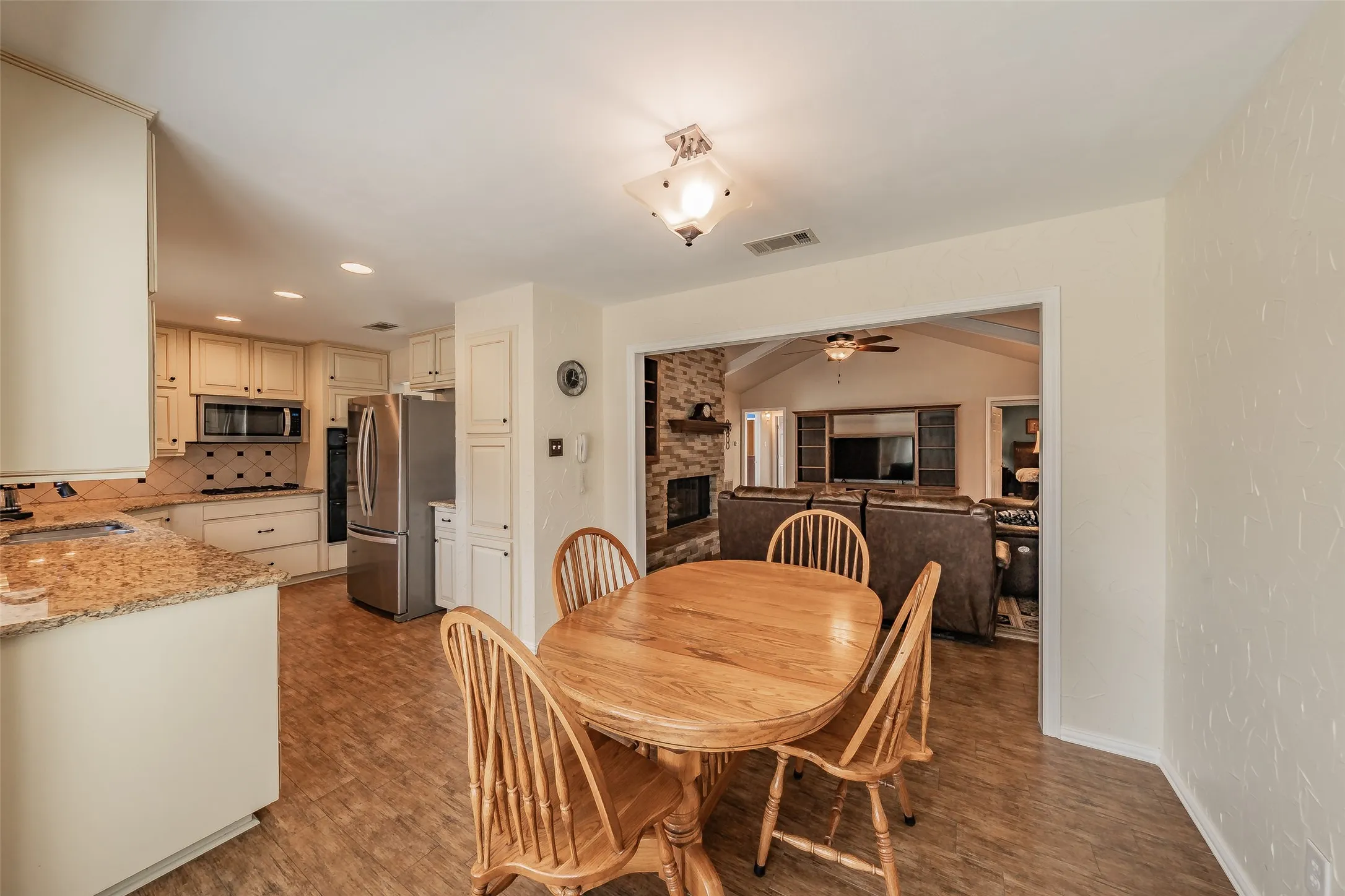 Kitchen featuring light-toned cabinetry, stainless steel appliances, and granite-style countertops