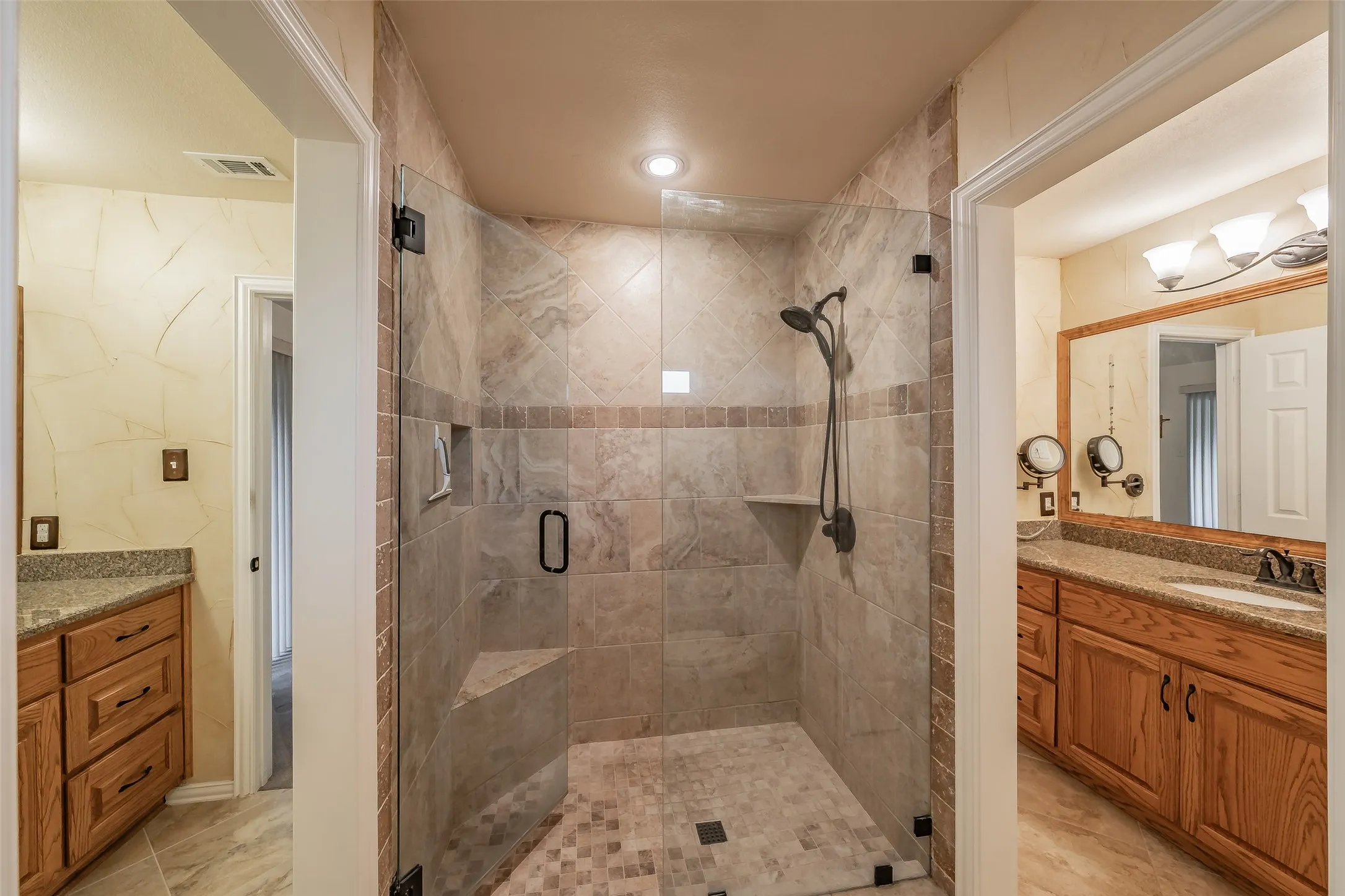 Walk-in shower with glass enclosure, built-in bench, and tiled walls