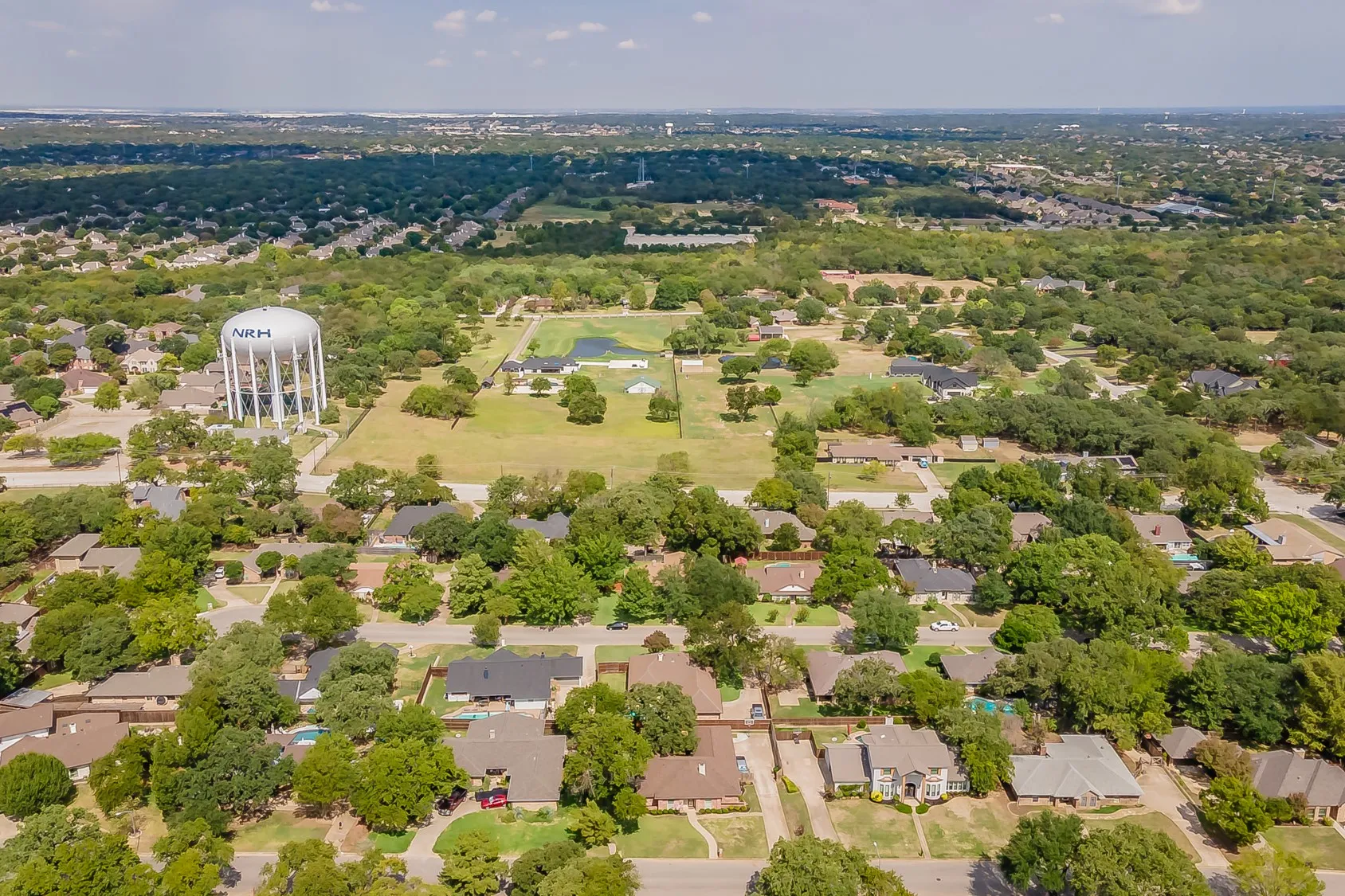 Aerial perspective of a residential area with varied rooflines and mature trees
