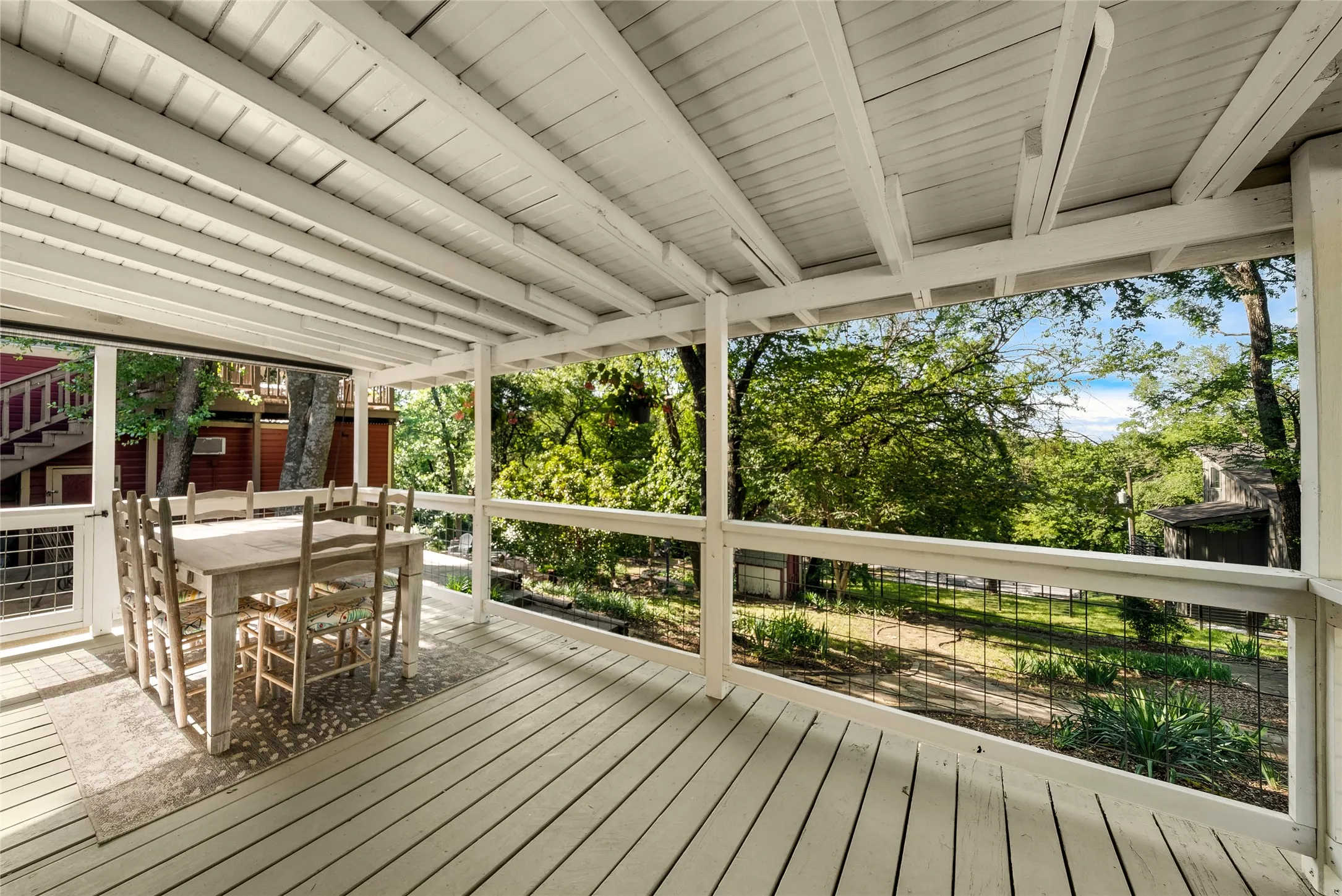 Covered porch with painted wood flooring and exposed wood beams