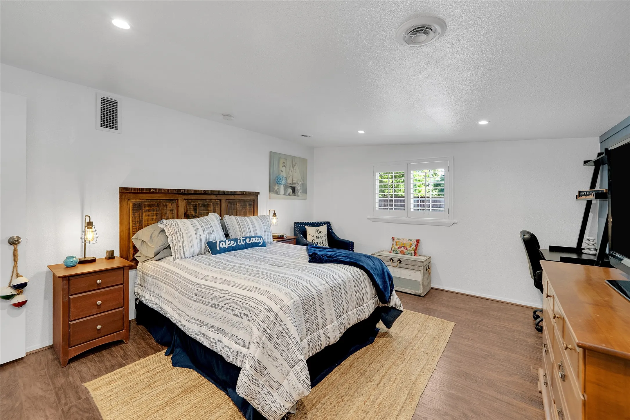 Recessed lighting, wood-finish flooring, and window with plantation shutters