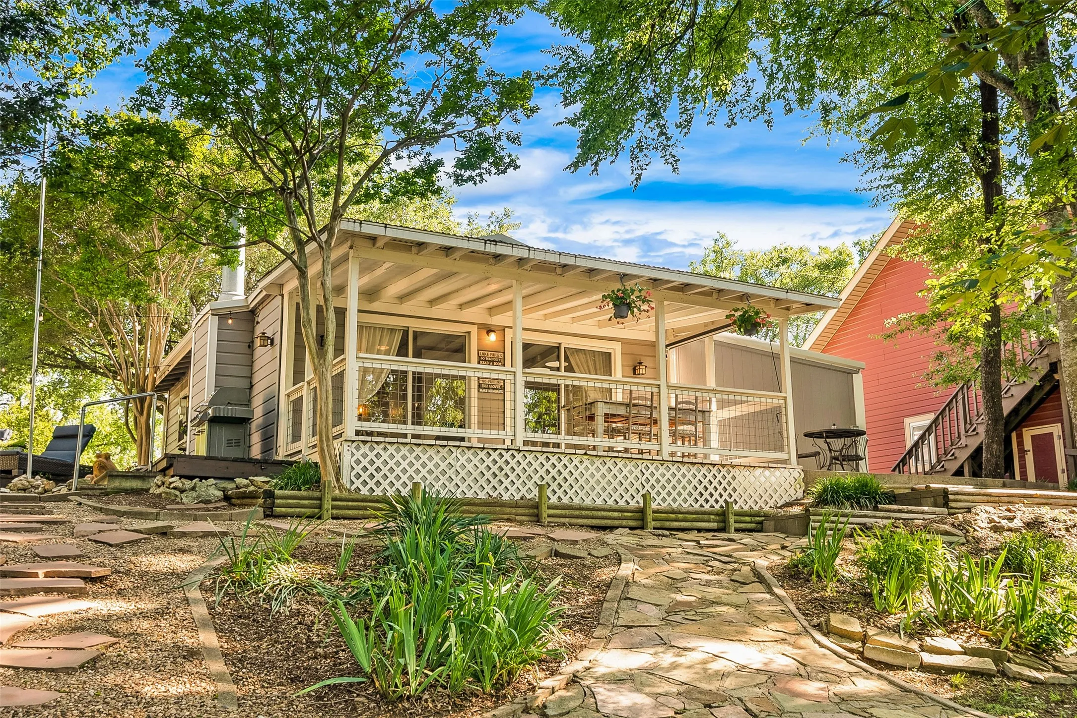 Expansive front porch with white lattice railing and a corrugated metal roof