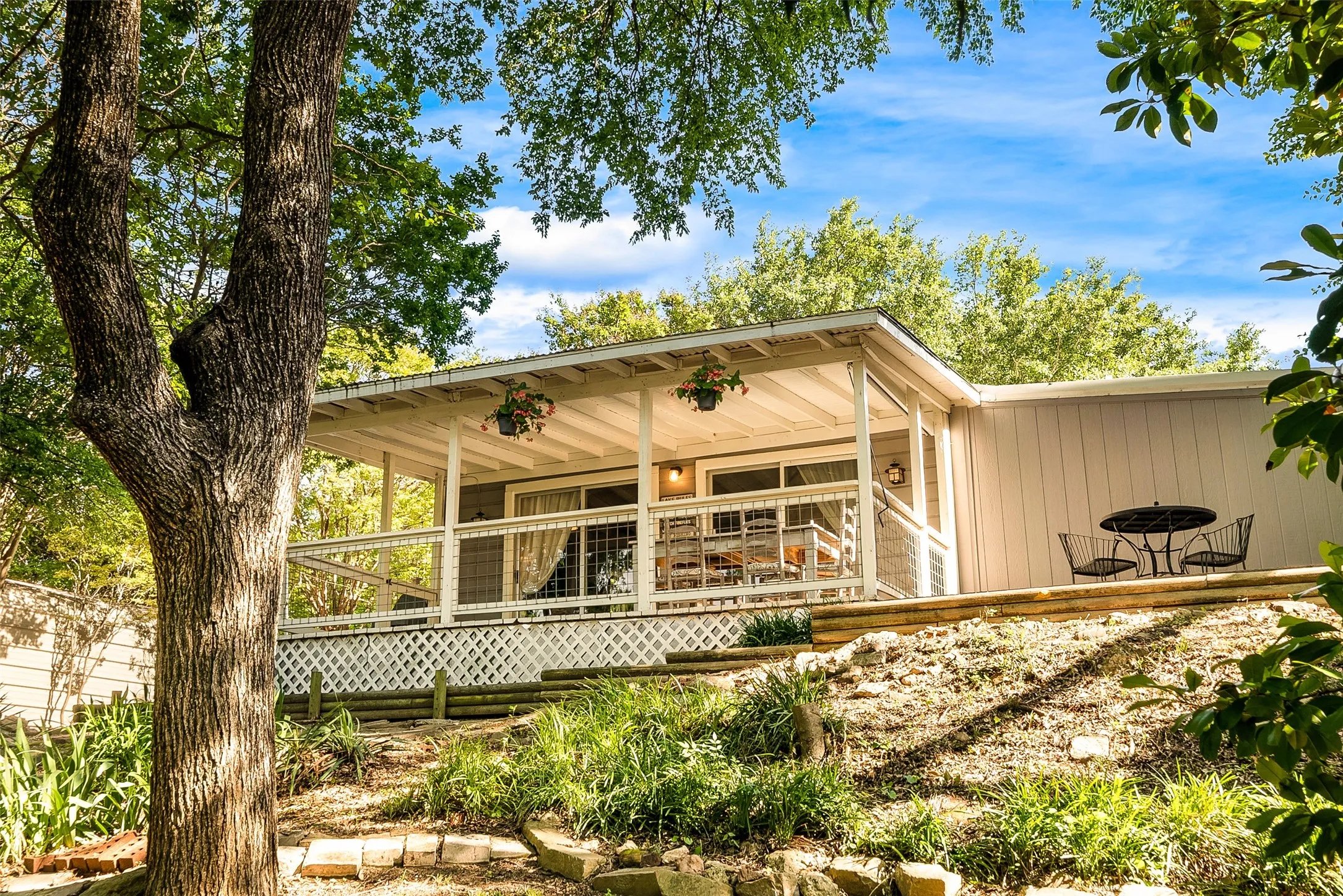 Expansive covered porch with white railing and lattice detailing