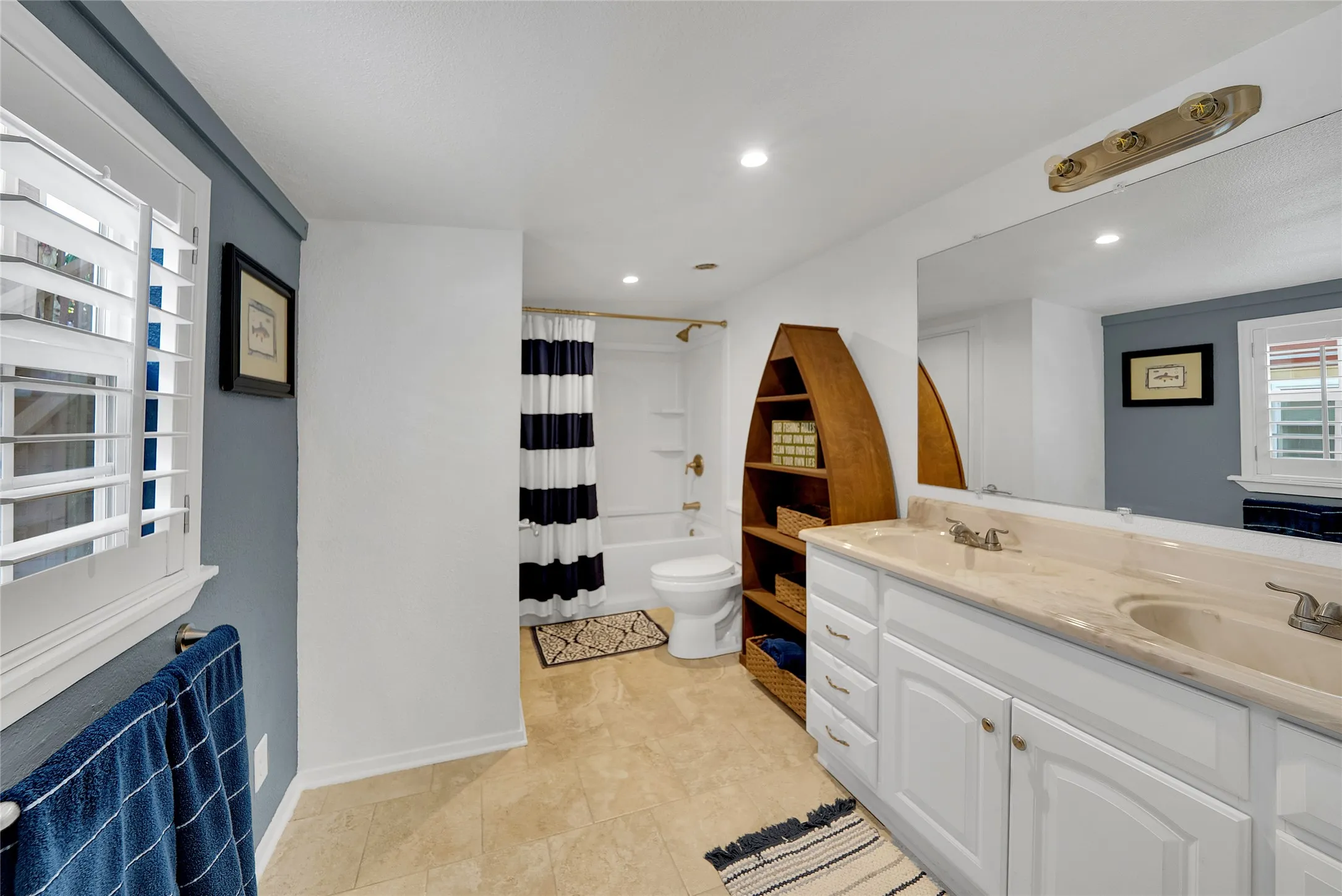 Dual vanity with undermount sinks, white cabinetry, and a full-width mirror