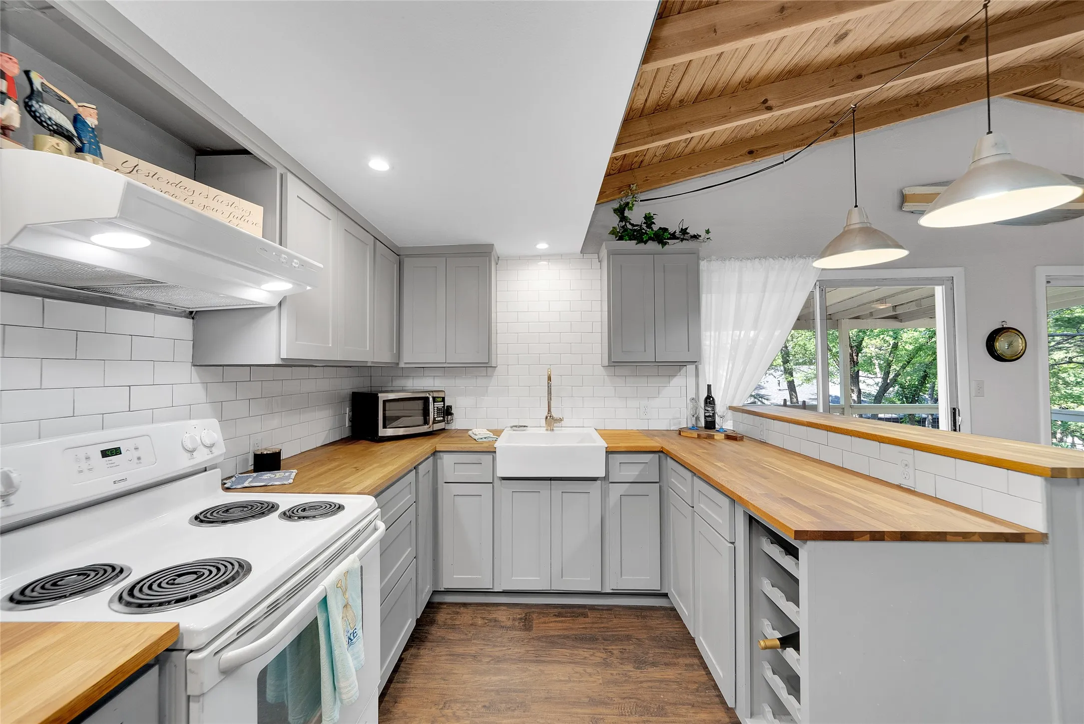 Kitchen featuring a vaulted wood-paneled ceiling, recessed lighting, subway tile backsplash, light gray cabinetry, and butcher block countertops
