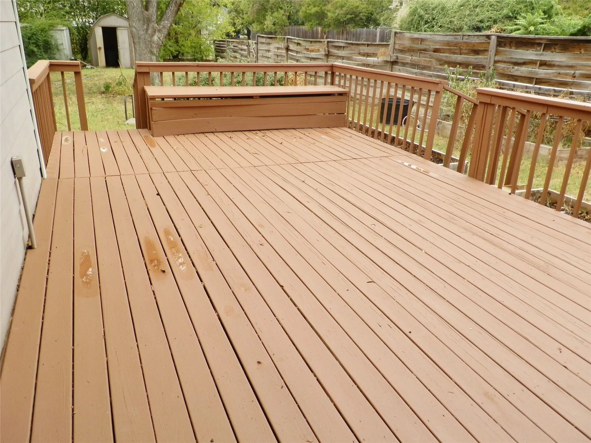 Spacious wood deck with built-in bench seating and wood railing