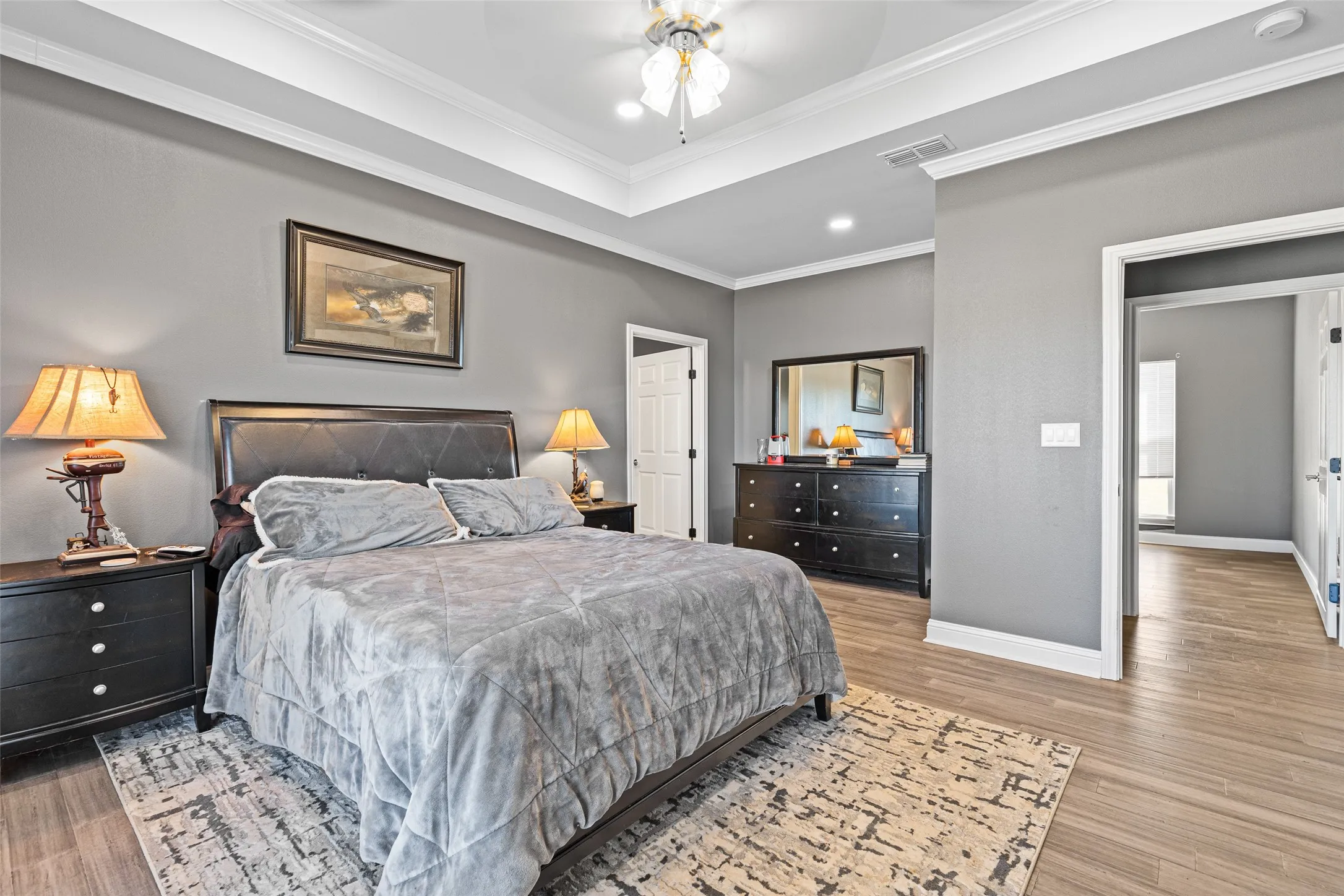 Bedroom featuring ceiling fan, ornamental molding, and light hardwood / wood-style floors
