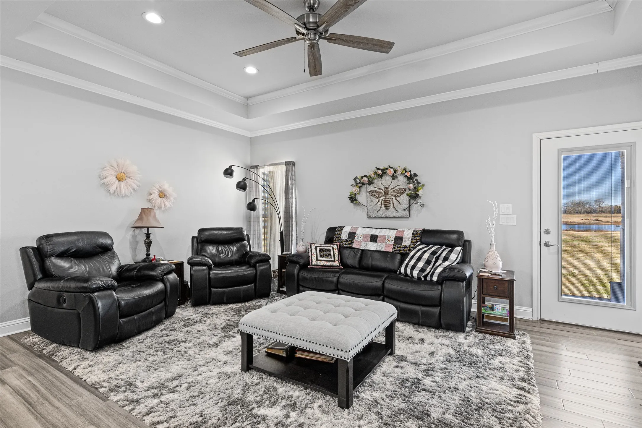 Living room featuring hardwood / wood-style flooring, crown molding, and a raised ceiling