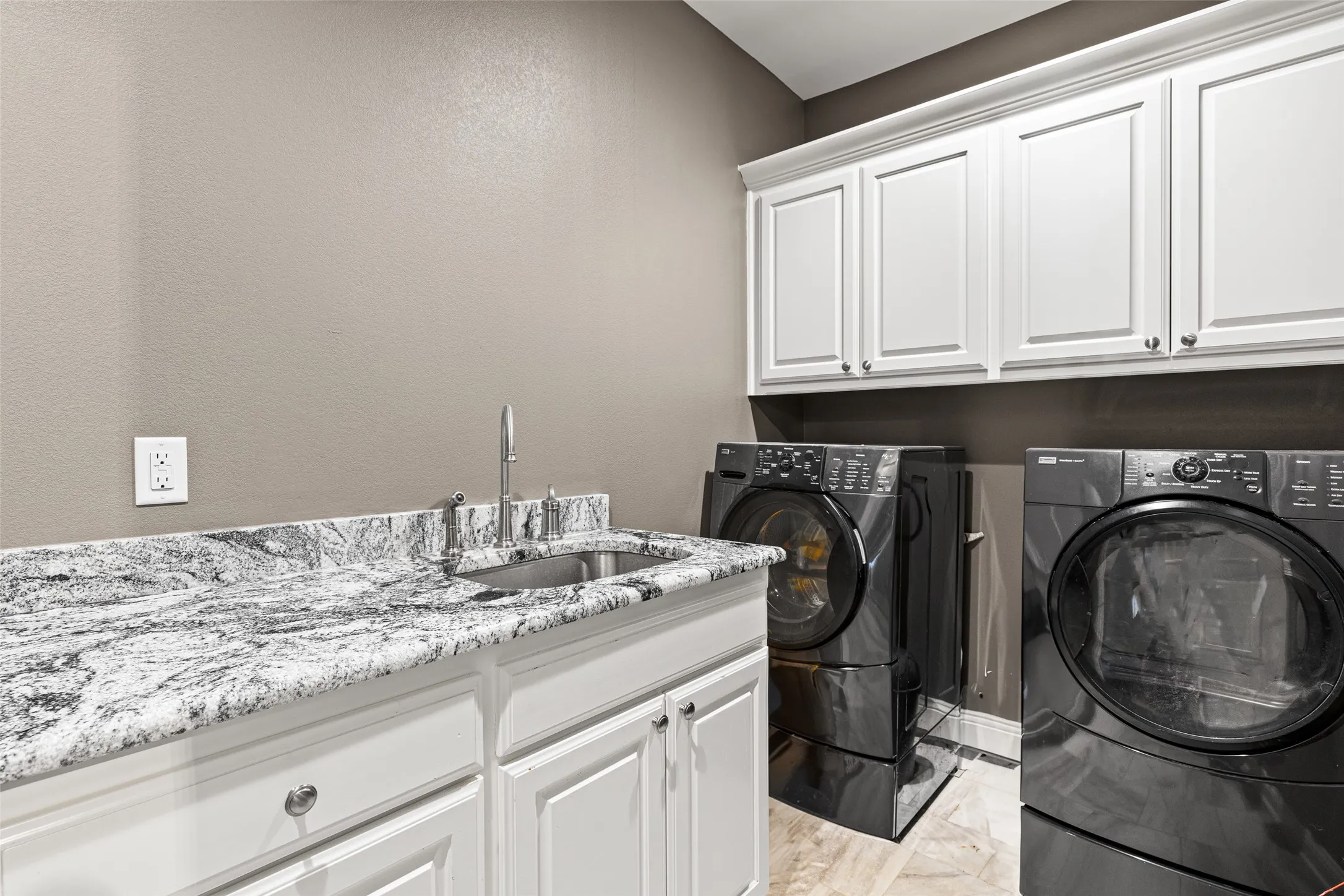 Laundry room with washer and dryer, sink, and cabinets