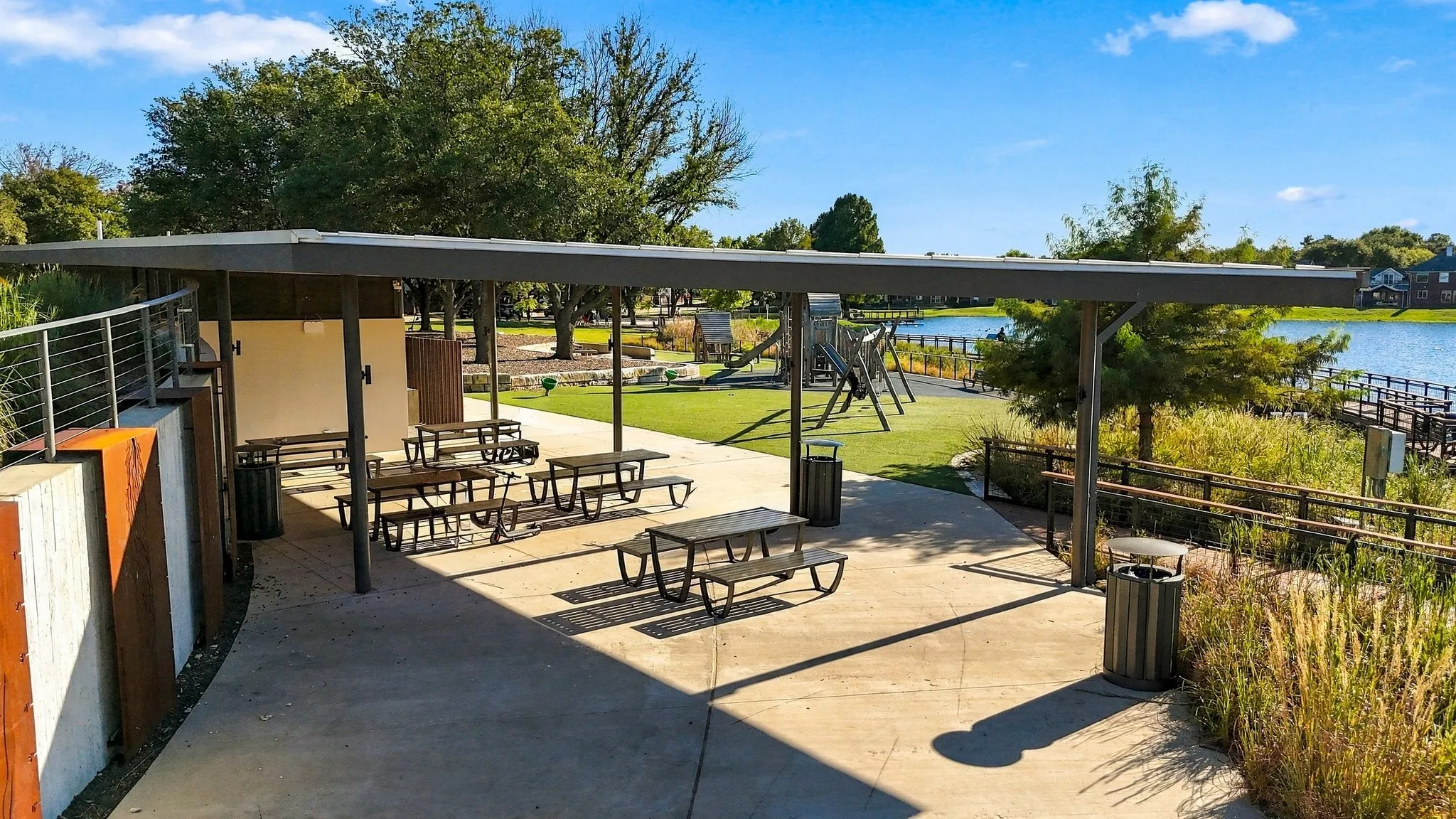 Covered outdoor patio  multiple picnic tables, a playground, and waterfront access with a dock
