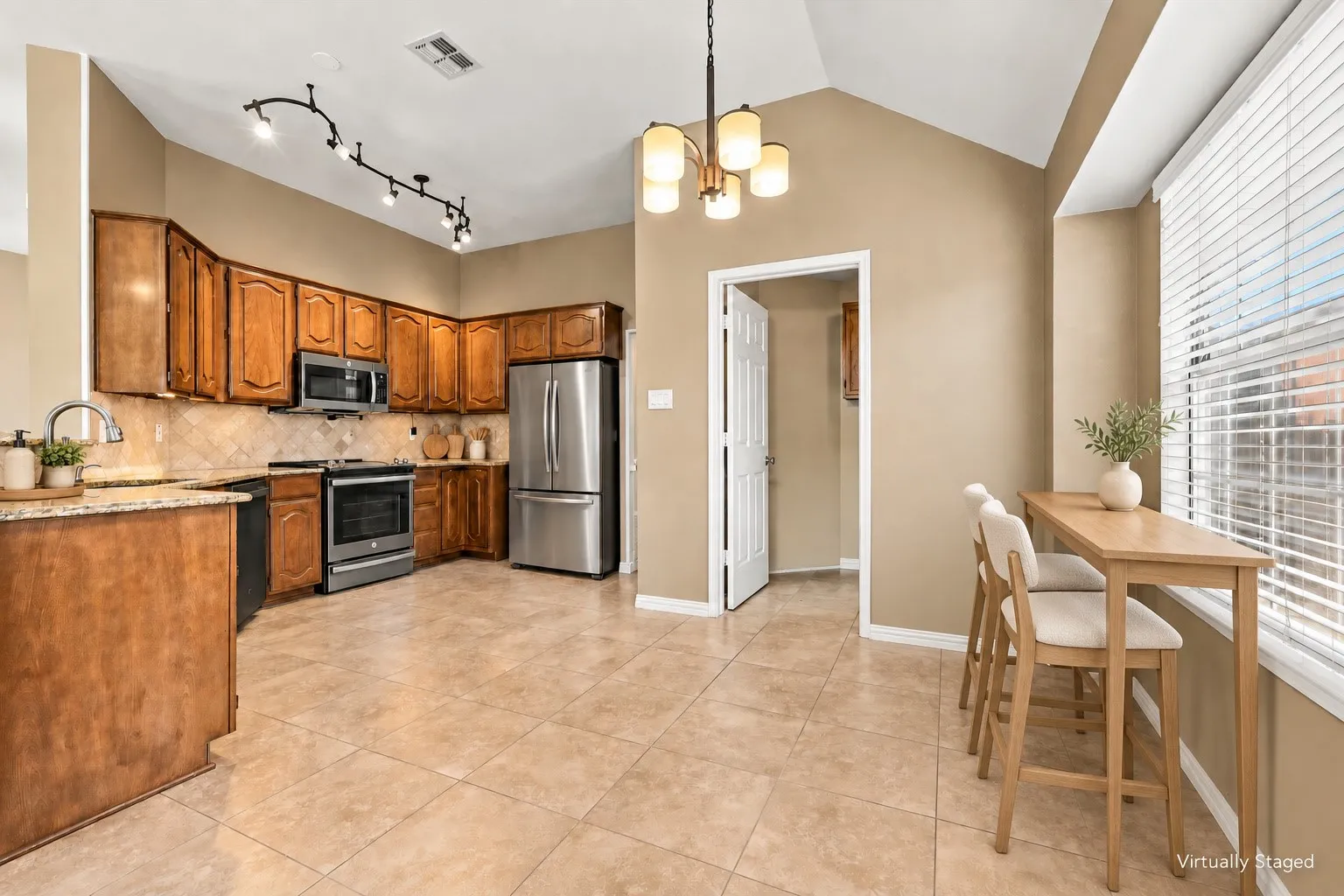 Kitchen featuring wood cabinetry, stainless steel appliances, tile backsplash, and tile flooring