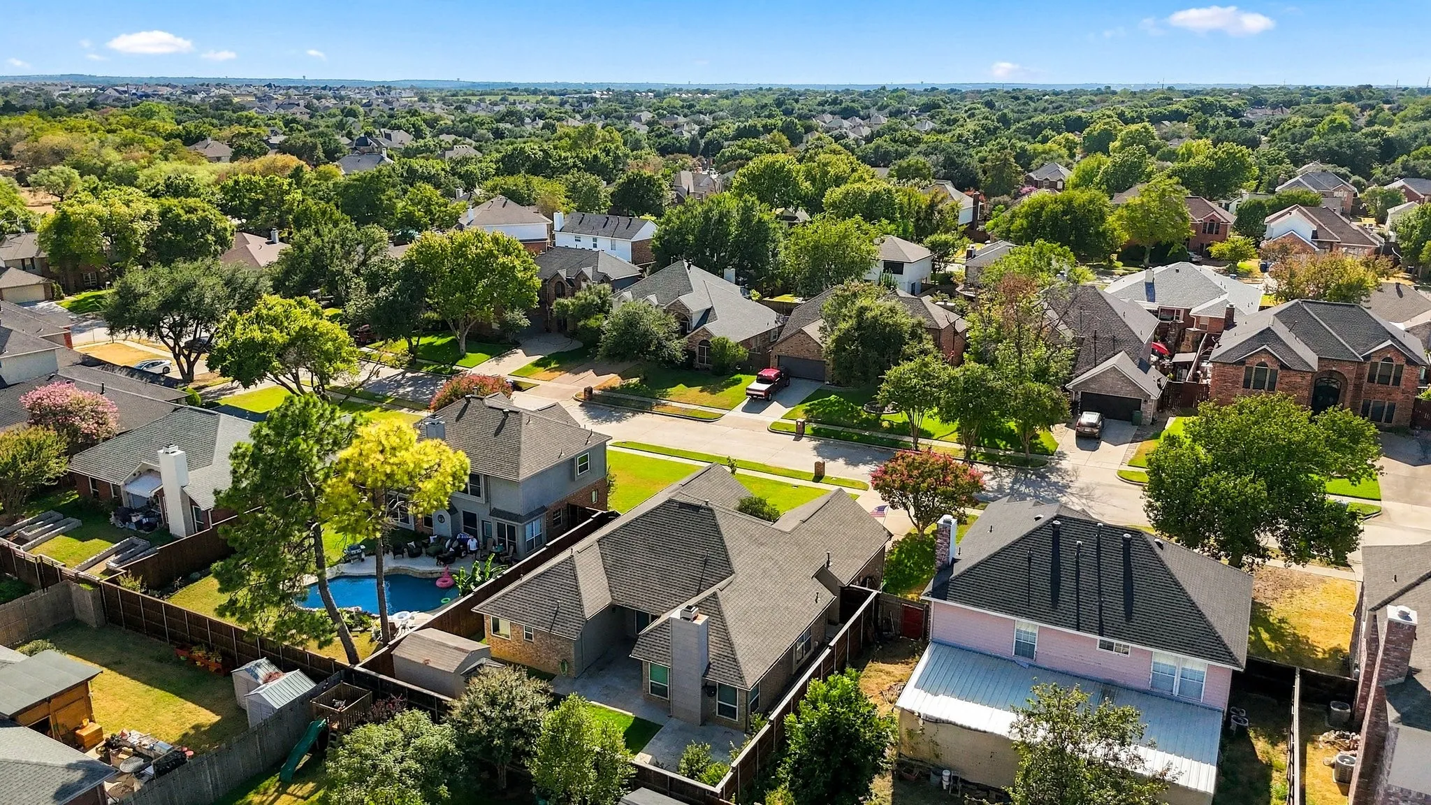 Aerial perspective showcasing residential properties with mature trees and paved streets