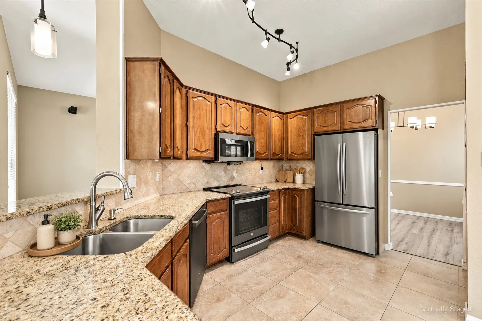 Kitchen featuring wood cabinetry, stainless steel appliances, granite countertops, and a tile backsplash
