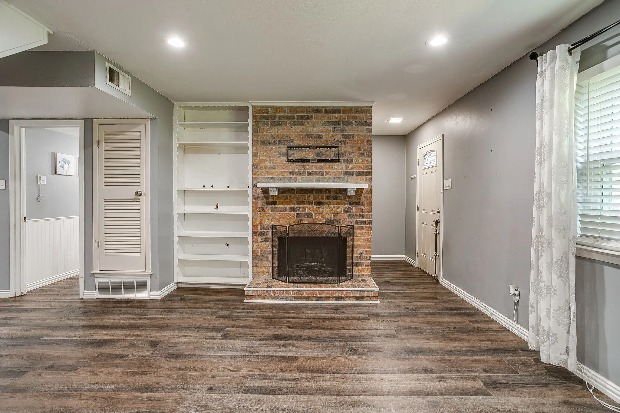 Brick fireplace with hearth, built-in shelving