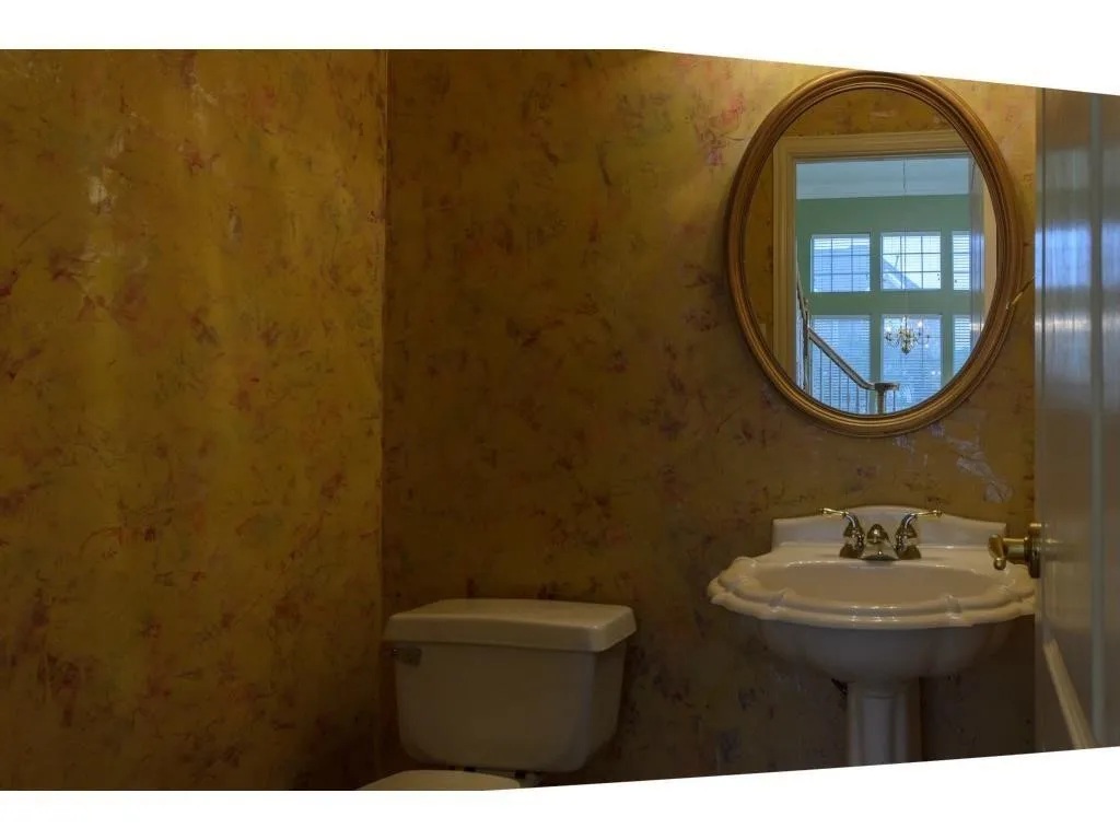 Pedestal sink with ornate gold-tone faucet