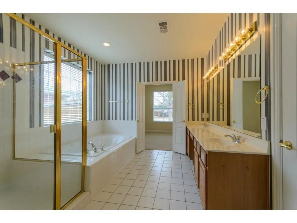 Dual vanity with wood-finish cabinetry, integrated sinks, and polished chrome fixtures