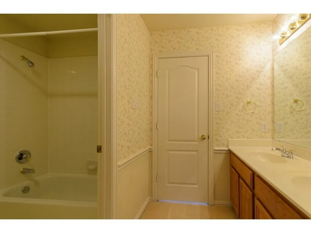 White bathtub and shower combination with chrome fixtures