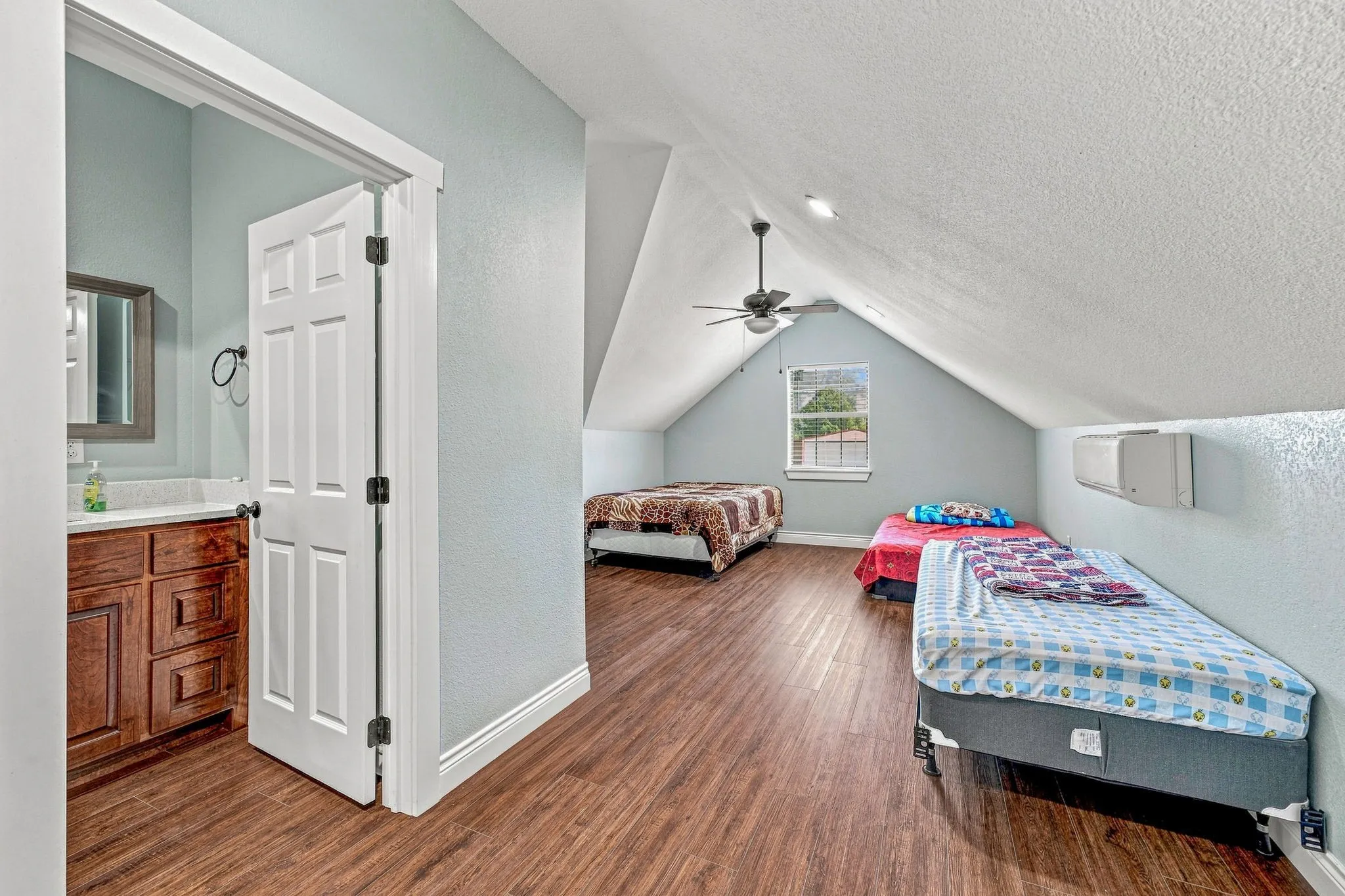 Wood-finish flooring, vaulted ceiling, ceiling fan, and built-in window