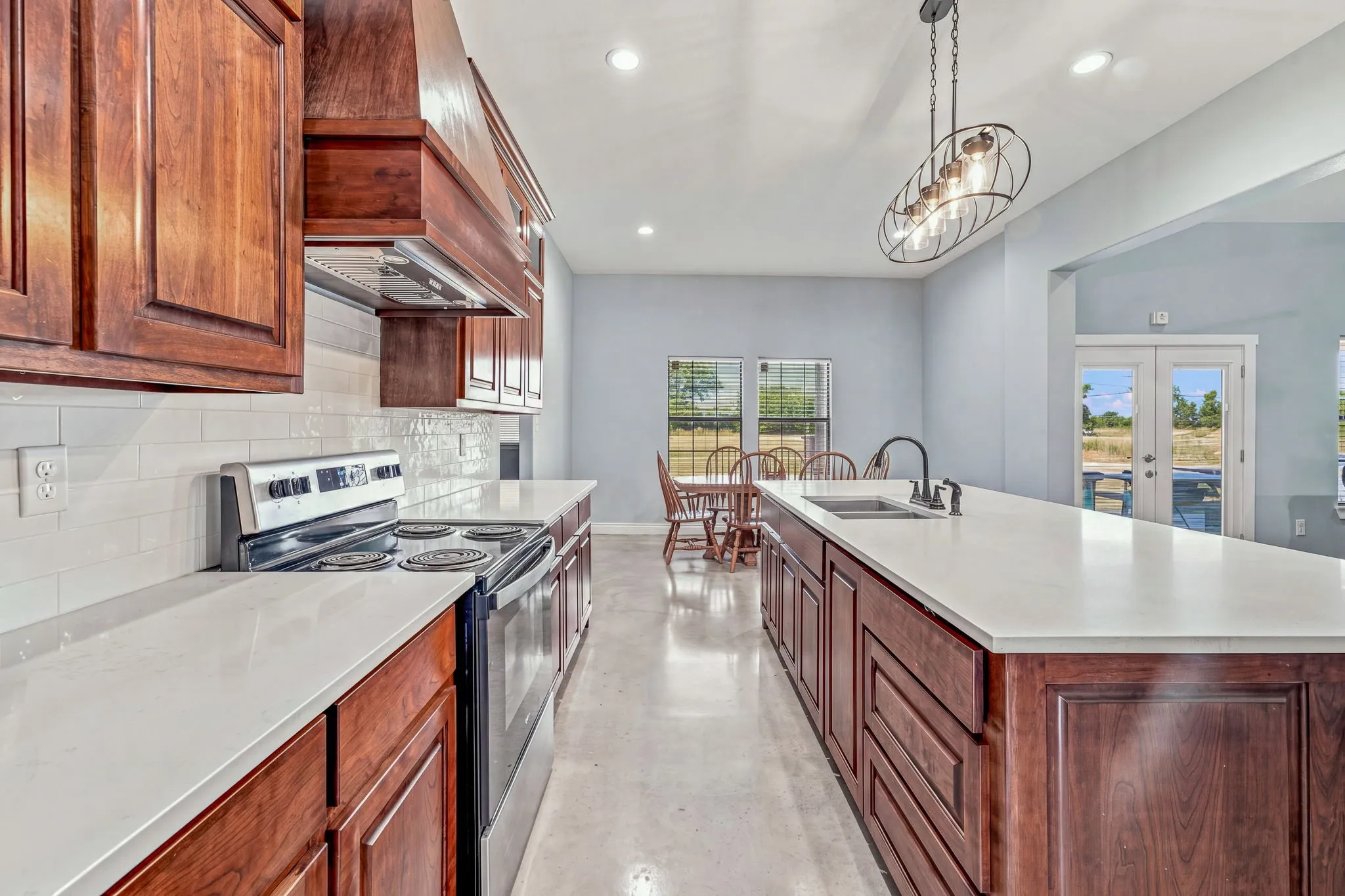Kitchen featuring wood cabinetry, white countertops, stainless steel appliances, and a tile backsplash