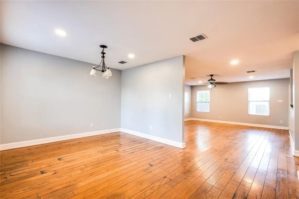 Hardwood flooring, recessed lighting, and a modern chandelier