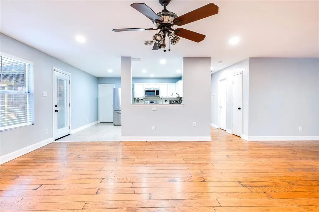 Wood-finish flooring throughout, with a ceiling fan and recessed lighting