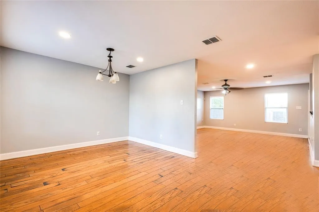 Wood-finish flooring throughout, recessed lighting, and a modern chandelier