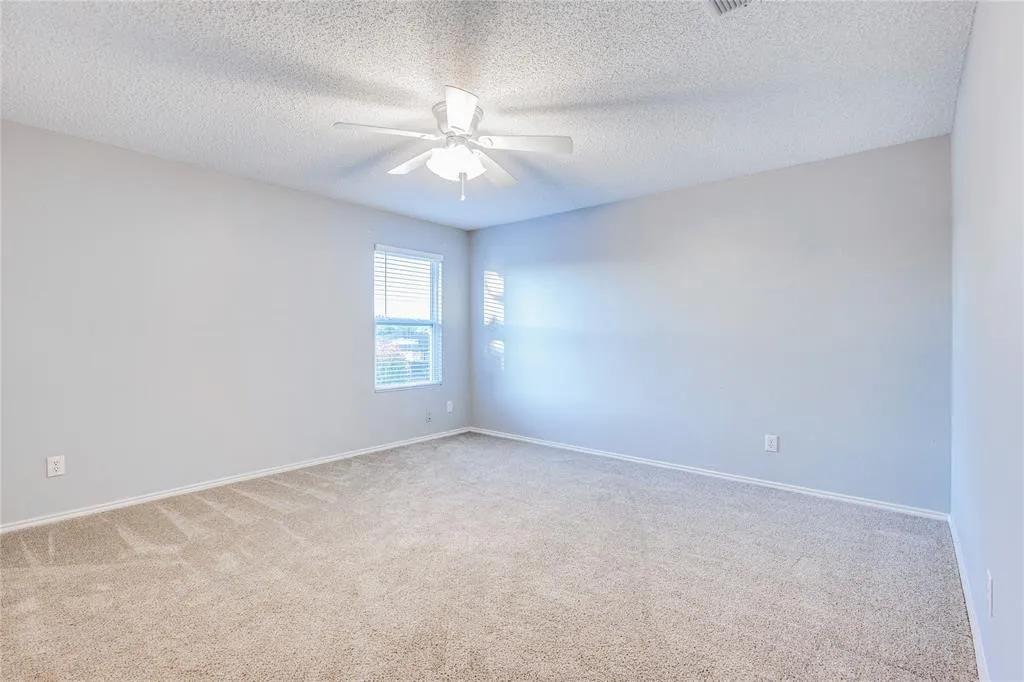 Carpeted flooring, window with blinds, ceiling fan with integrated lighting, and neutral wall paint