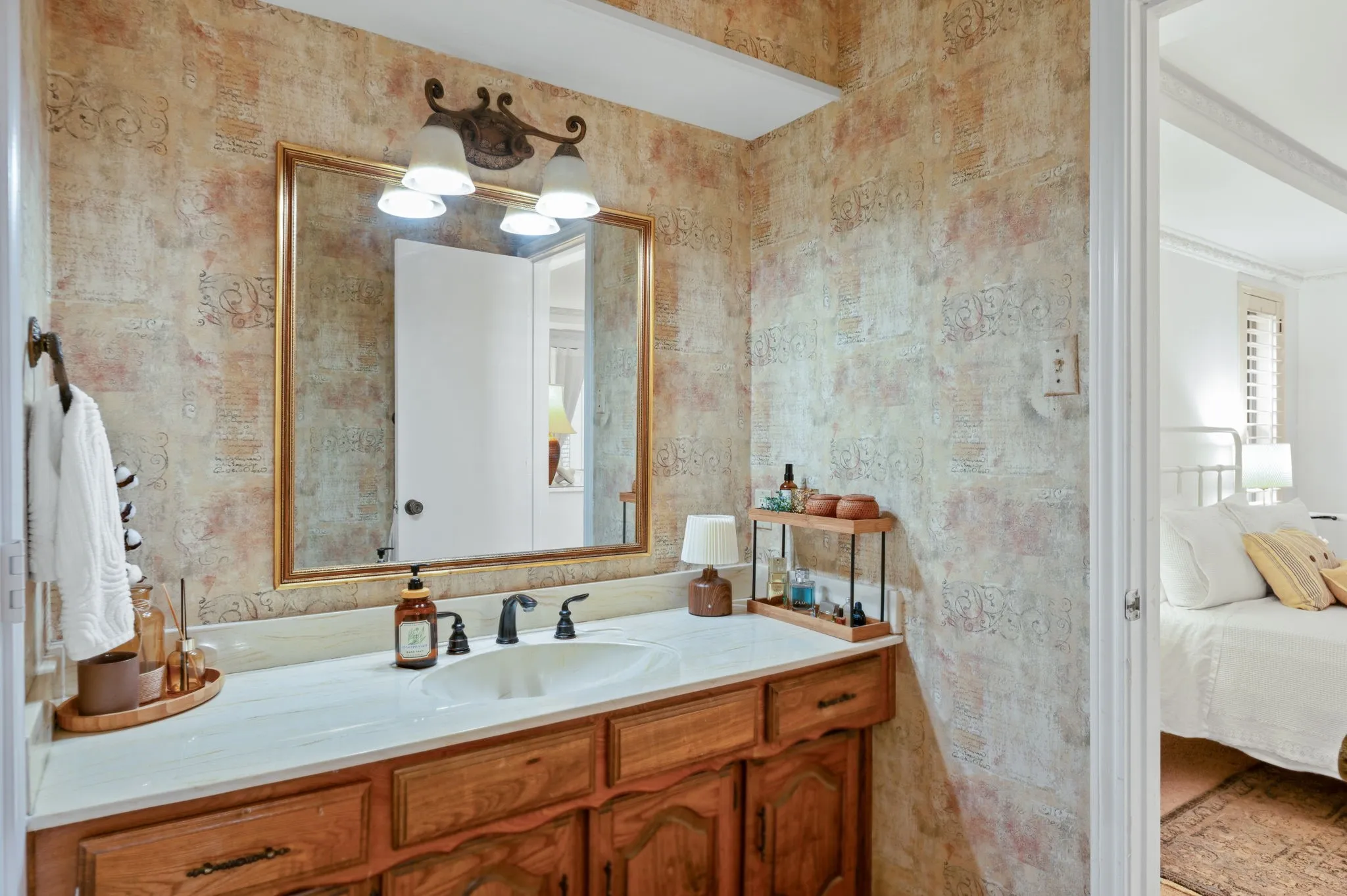 Bathroom vanity with a white countertop, oval sink, and dark-finished faucet