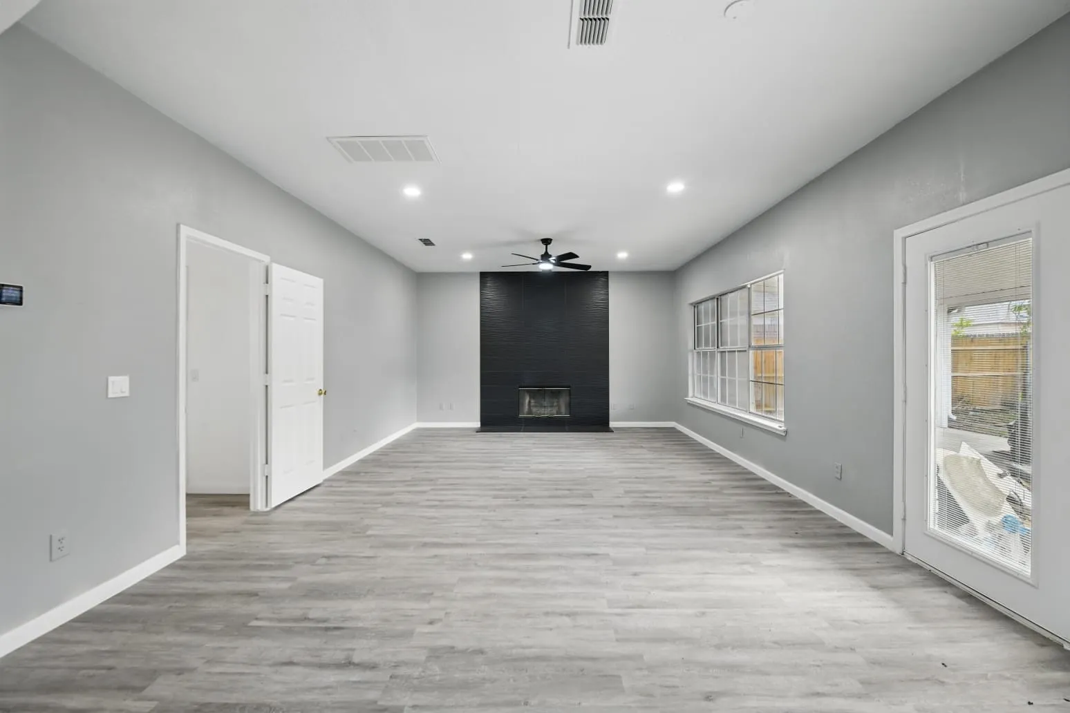 Unfurnished living room featuring recessed lighting, a ceiling fan, a fireplace, and wood finished floors