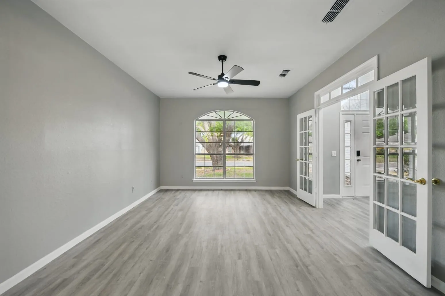 Spare room with french doors, wood finished floors, and ceiling fan