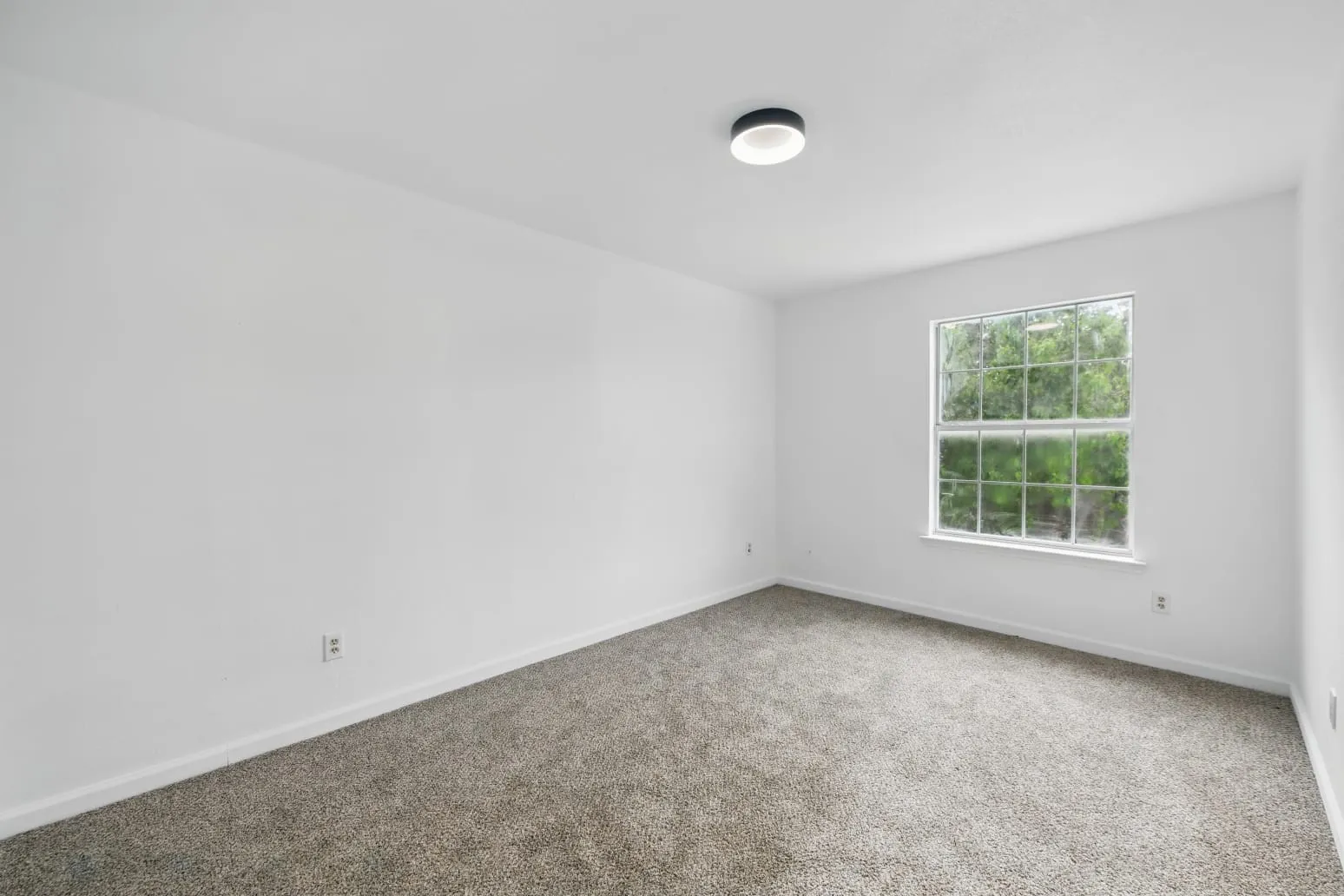 Carpeted spare room featuring baseboards