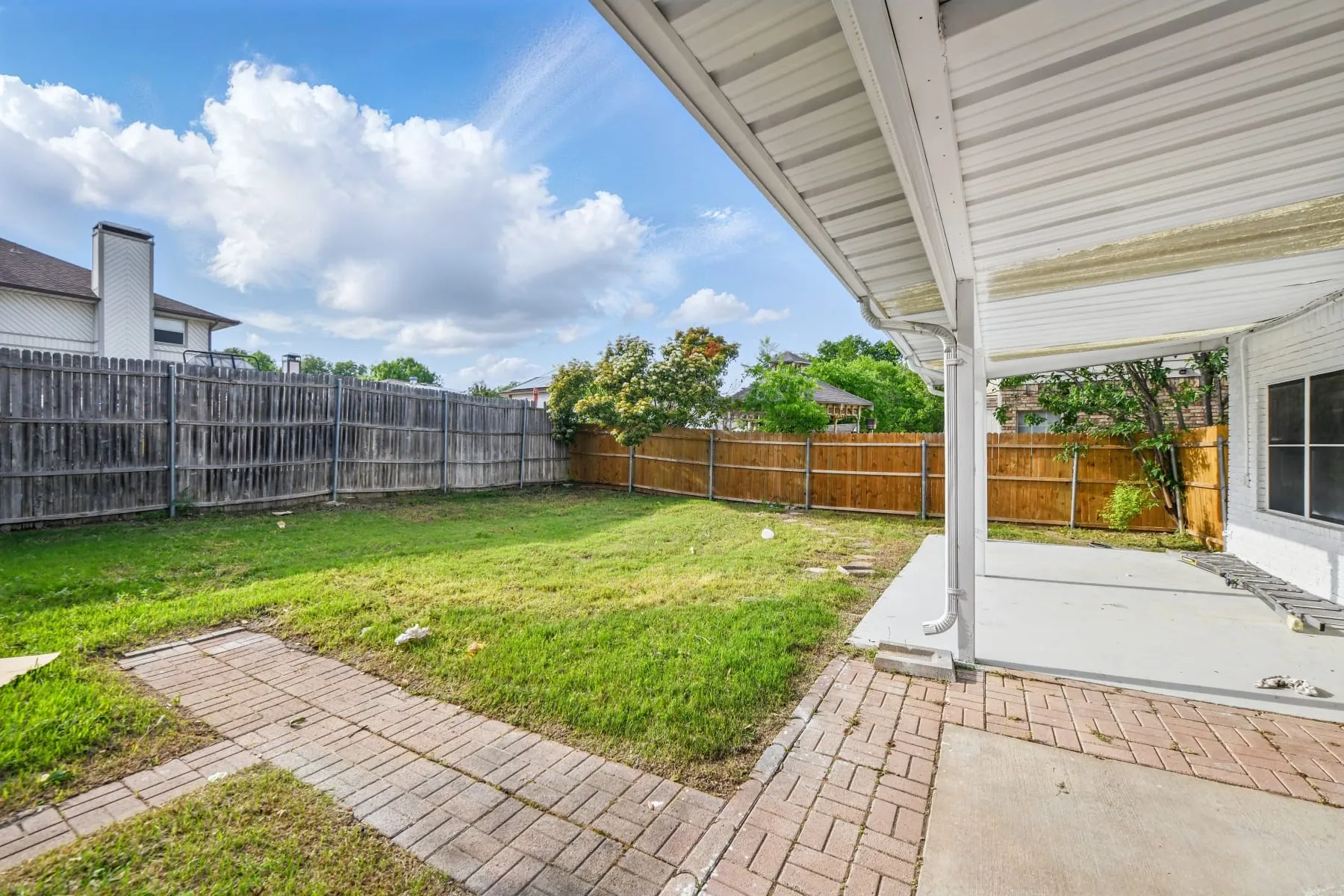 Fenced backyard with a patio area
