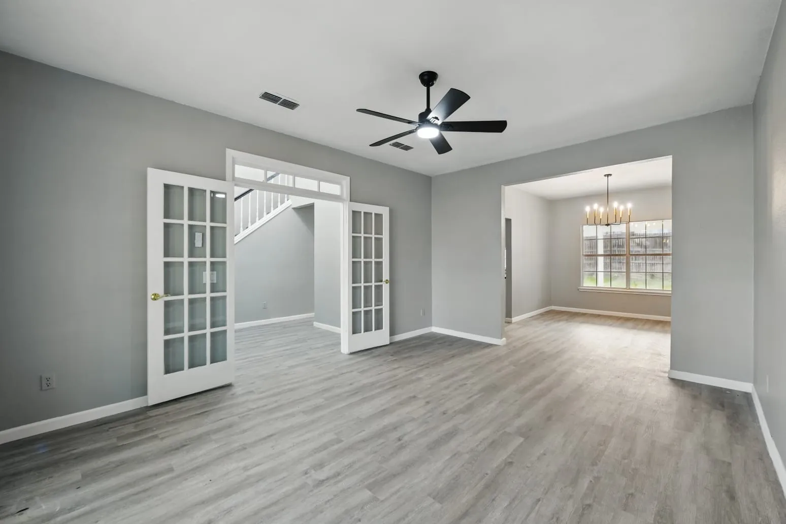 Unfurnished room featuring french doors, a chandelier, wood finished floors, and ceiling fan