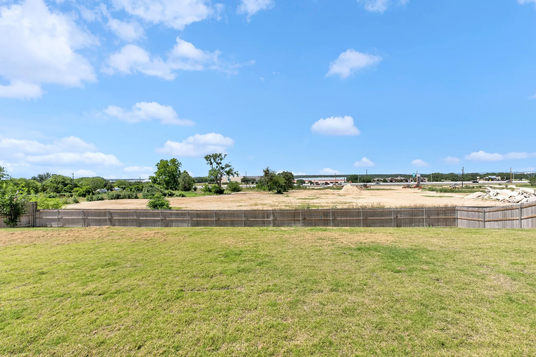 Expansive grassy yard with wood fencing