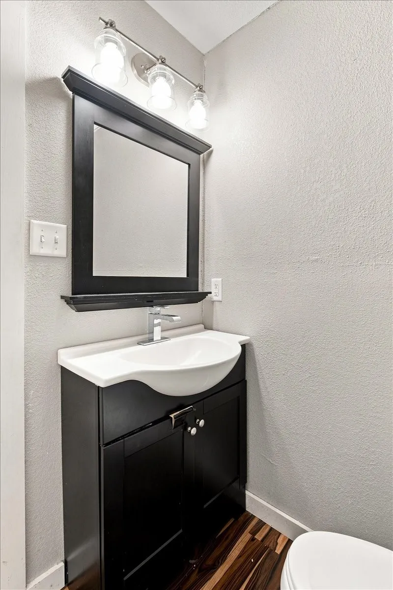 Black vanity with a white integrated sink and chrome faucet