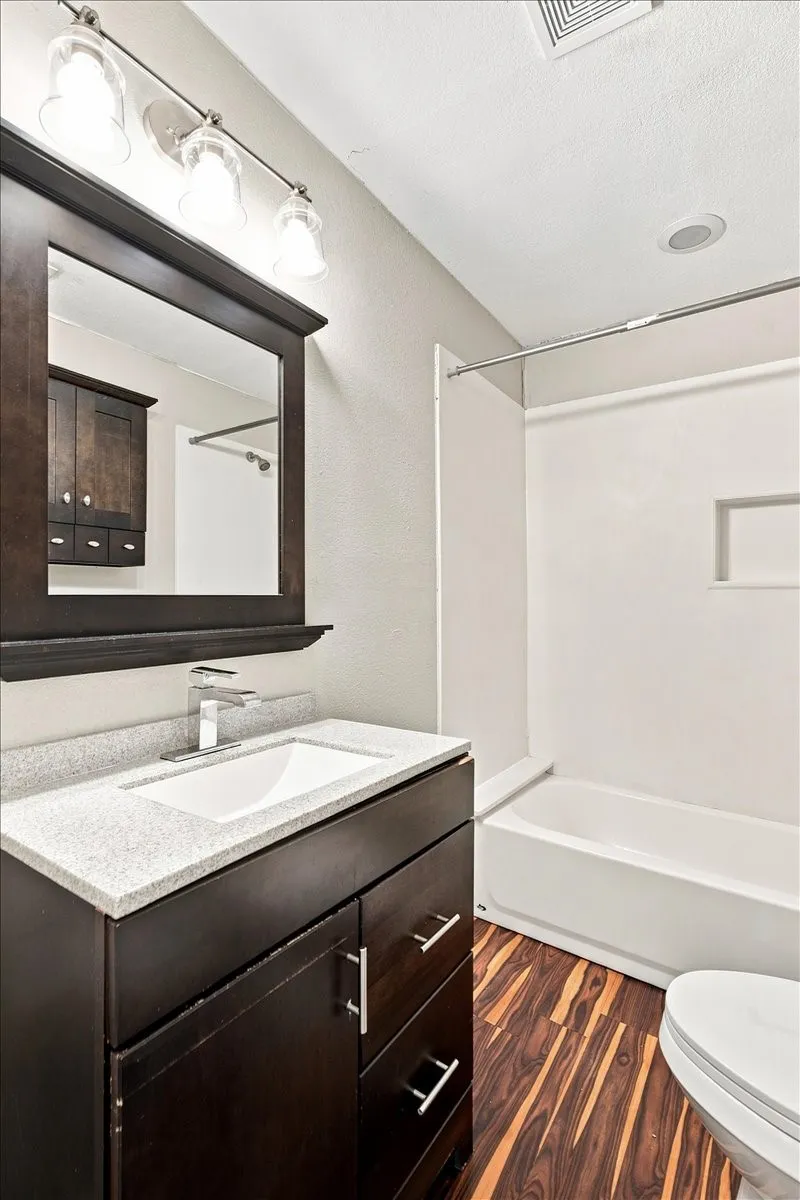 Dark wood-finish vanity with an integrated sink and light-colored countertop
