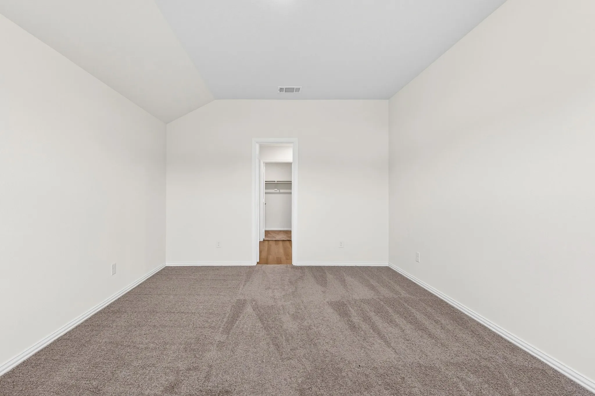 Dual vanity with undermount sinks, wood-finish flooring, recessed lighting, and a spacious closet with shelving