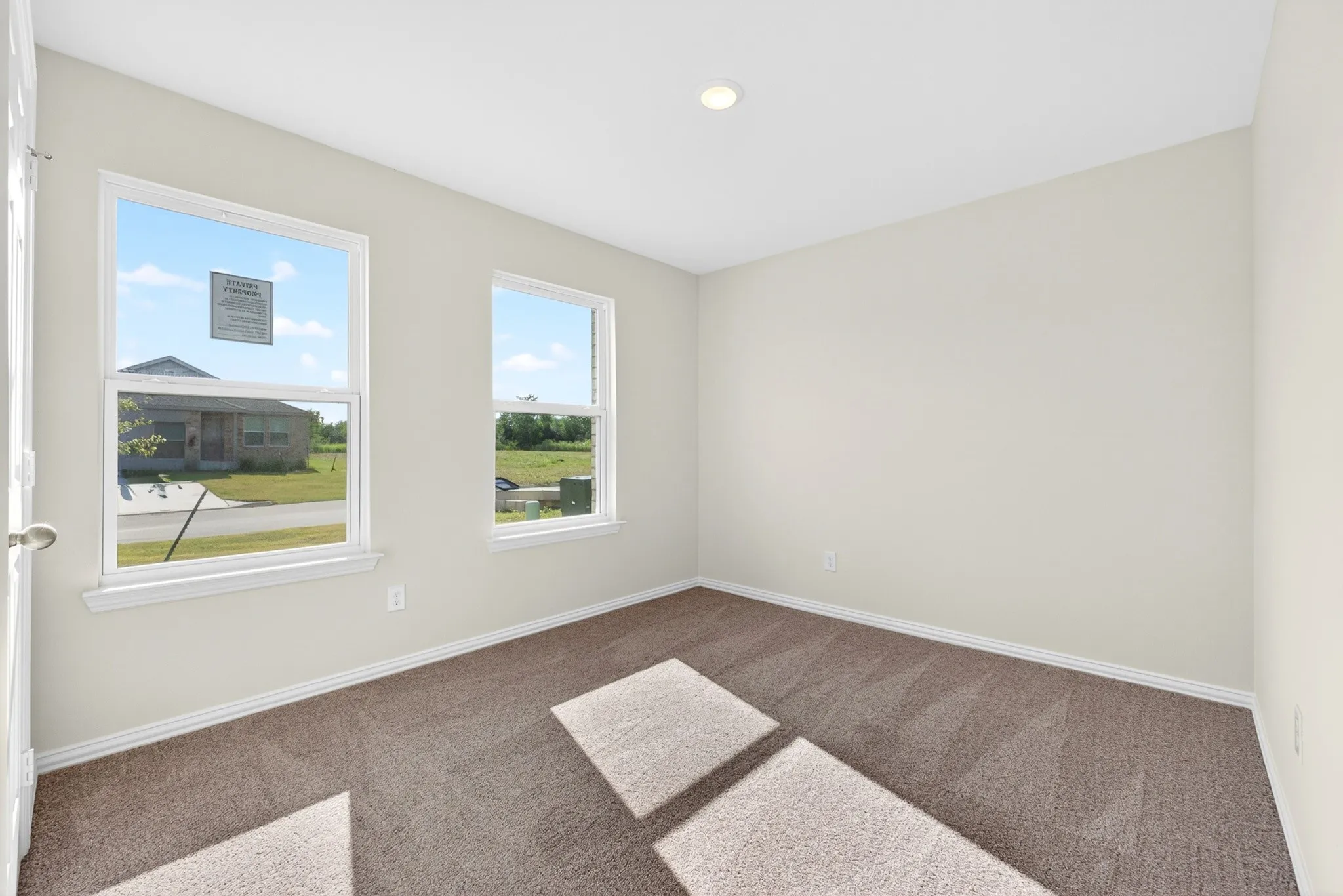 Window with white trim, light-colored walls, and neutral carpet flooring