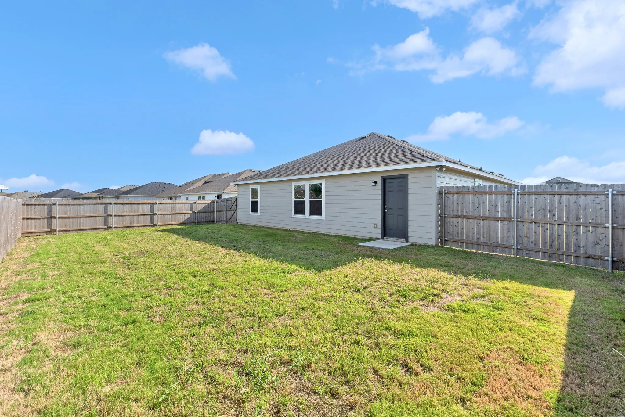 Expansive fenced backyard with a concrete patio
