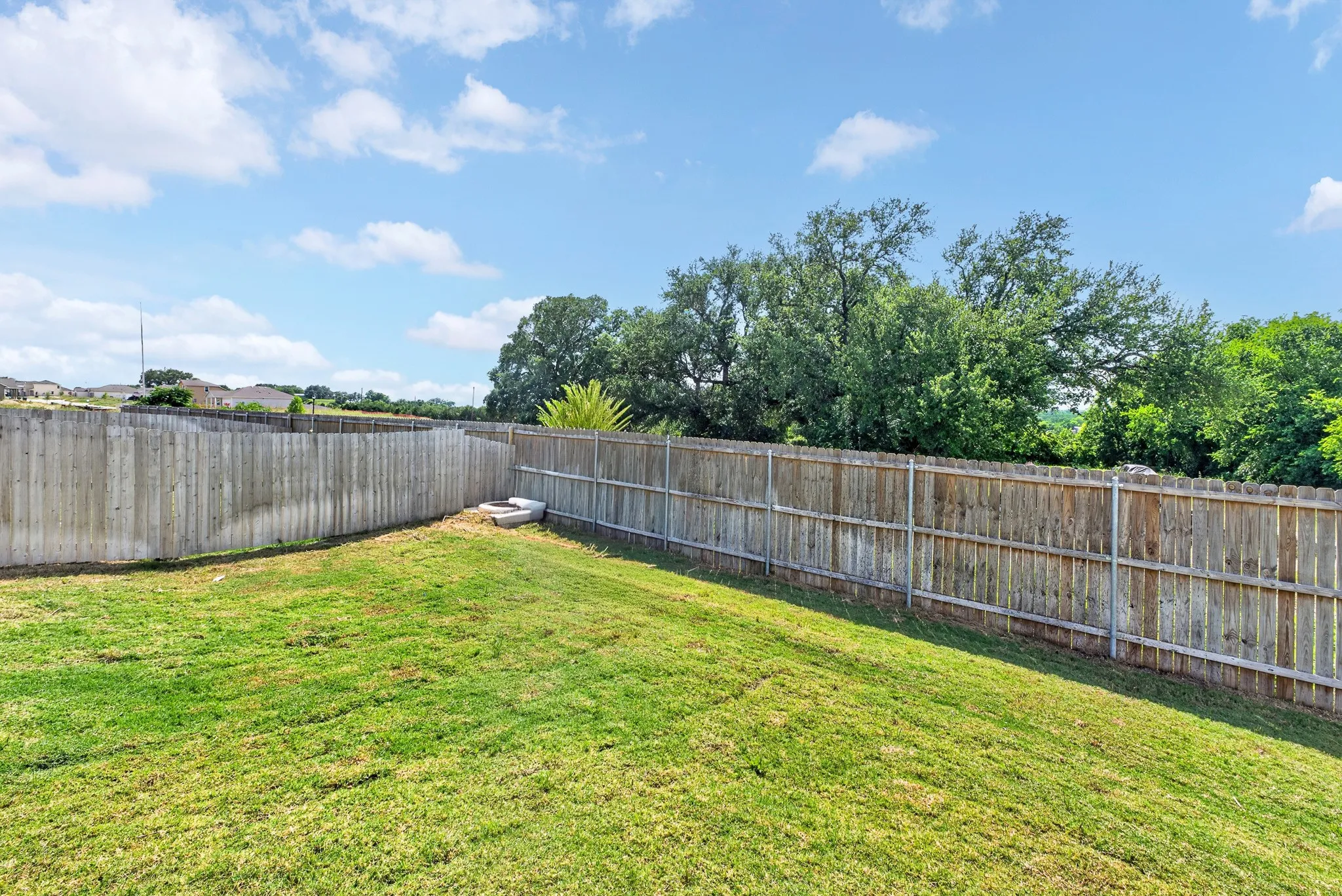 Expansive grassy yard with wood perimeter fencing