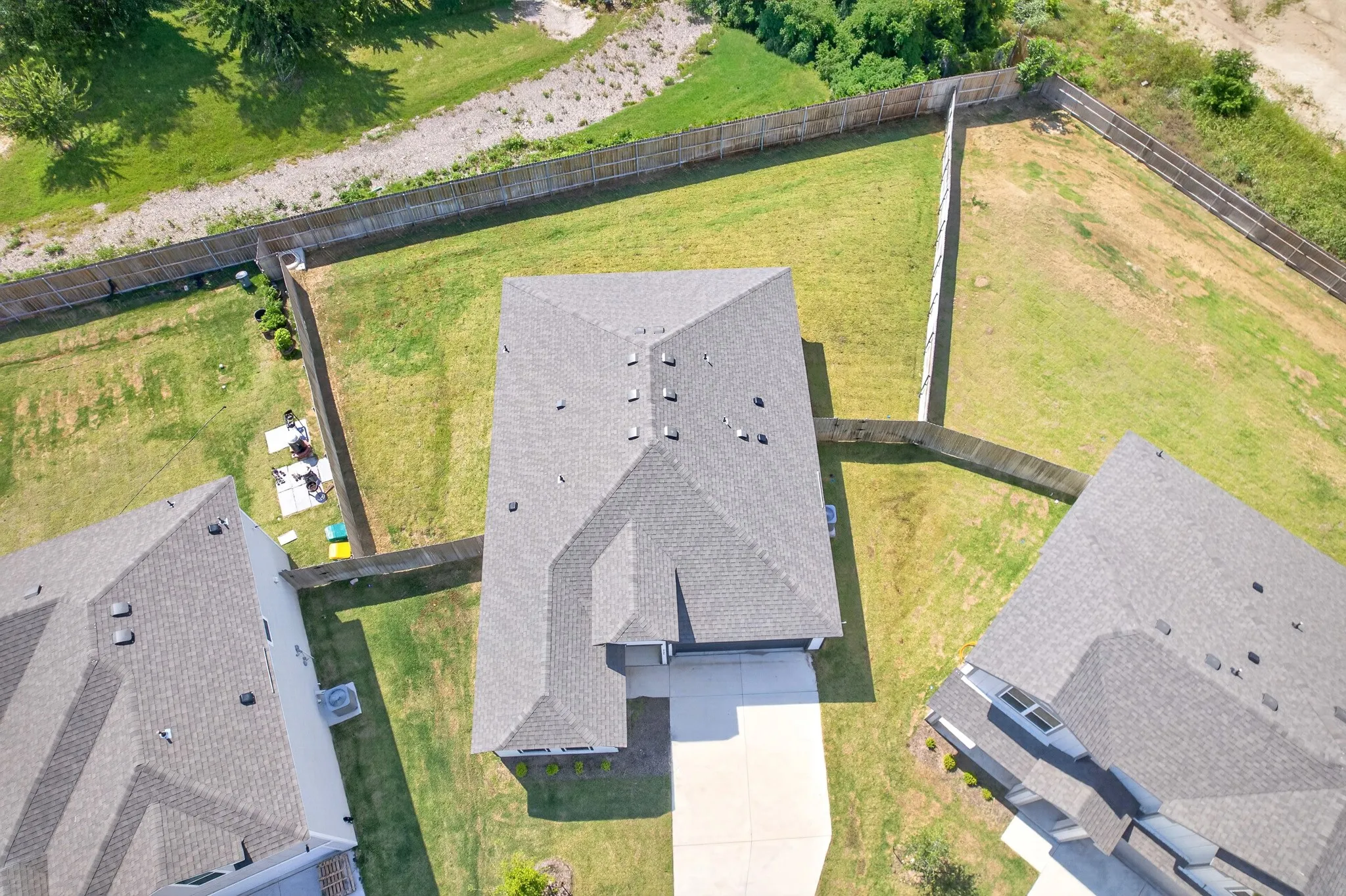 Expansive lot featuring a fenced backyard, a large driveway, and a new shingle roof