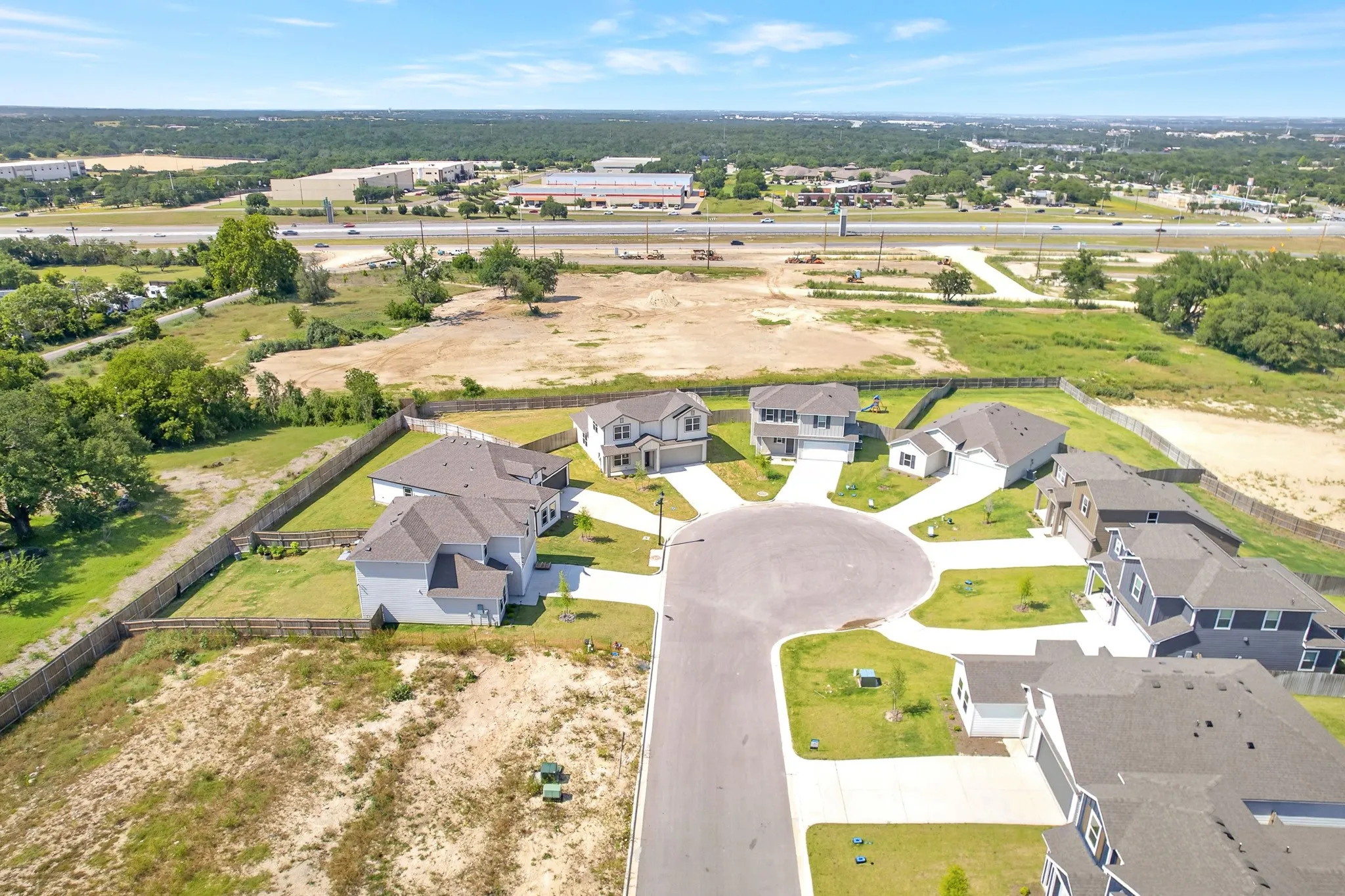 Cul-de-sac street featuring new construction residences with gray shingle roofing