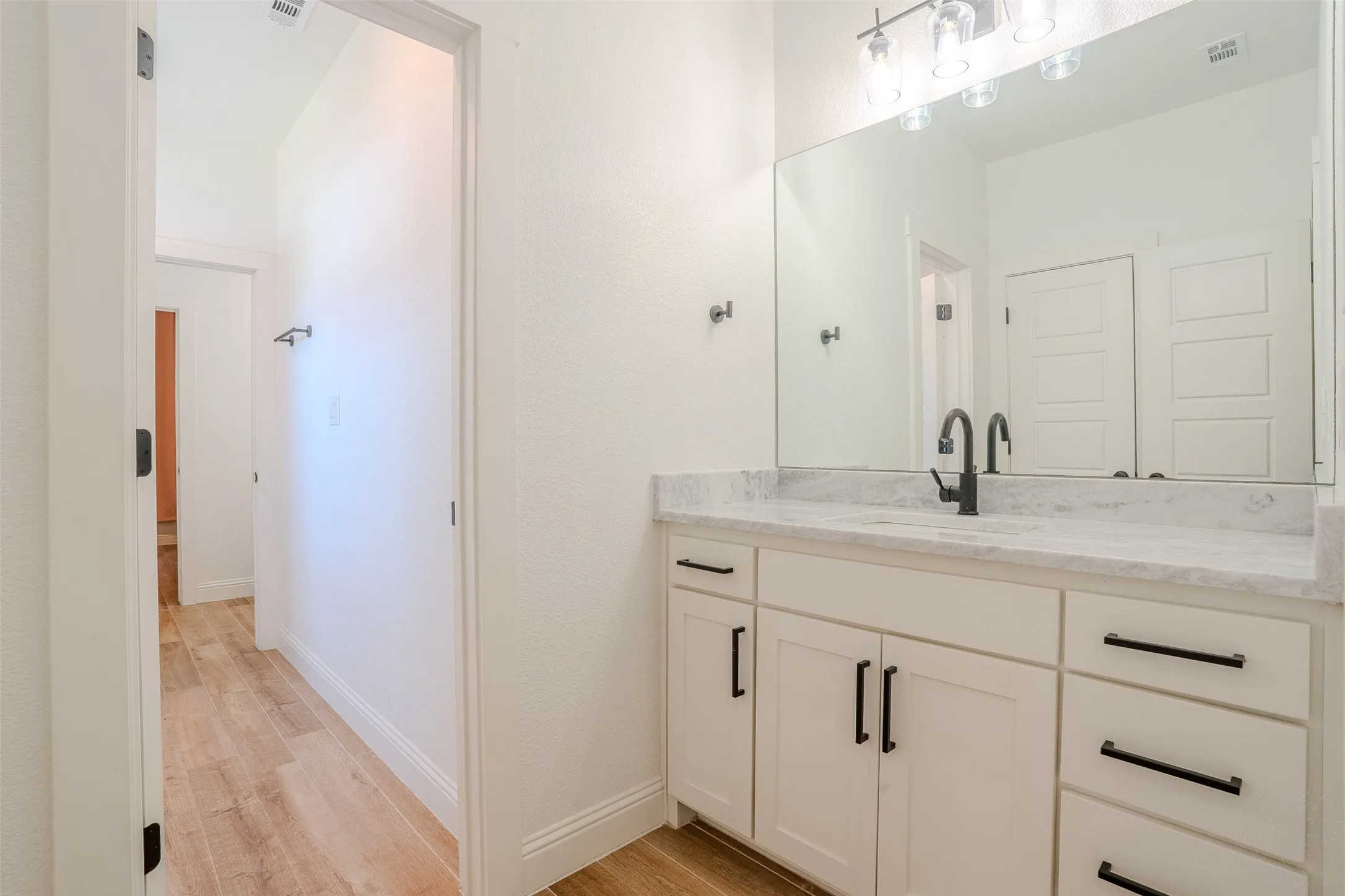 Jack and Jill Bathroom just off of Bedroom #2.  vanity with black hardware, Granite countertop, undermount sink, and black faucet