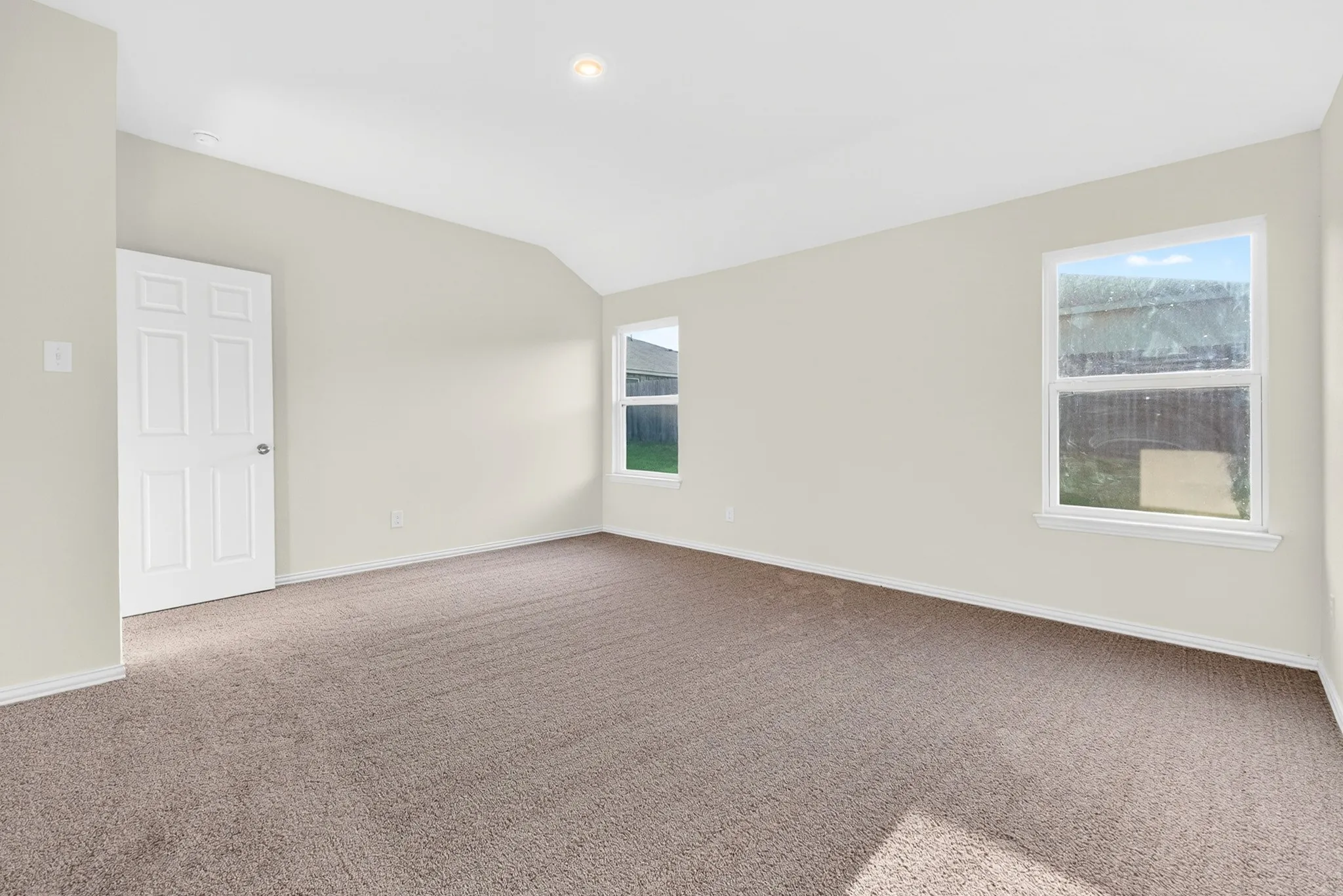 Neutral wall color, vaulted ceiling, recessed lighting, carpet flooring, and white trim