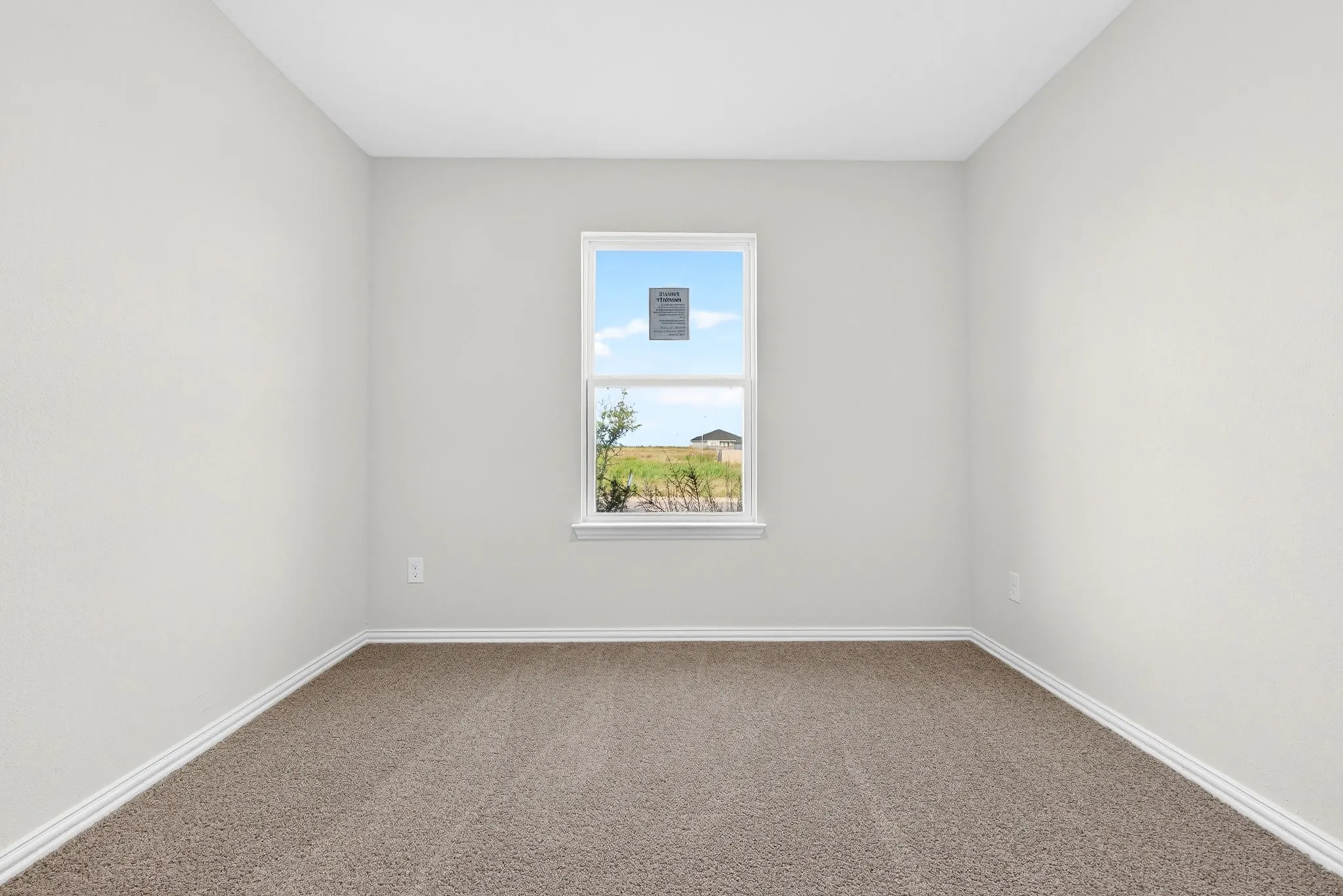 Neutral wall paint, plush carpet flooring, and a window with white trim