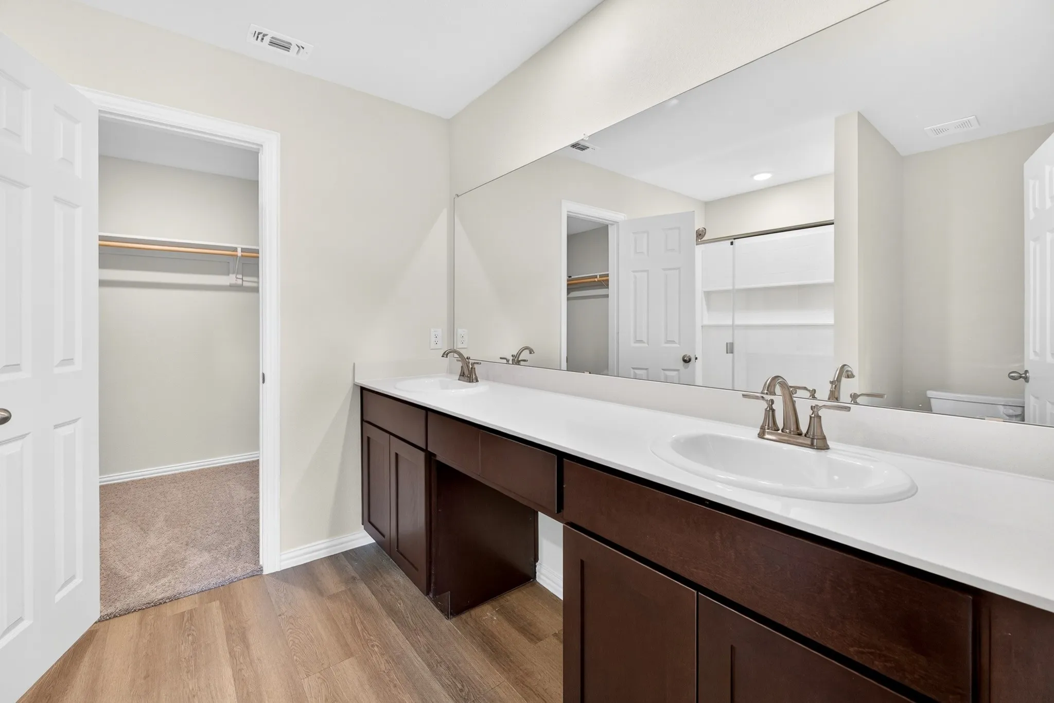 Double vanity with dark wood-finish cabinetry and white countertops