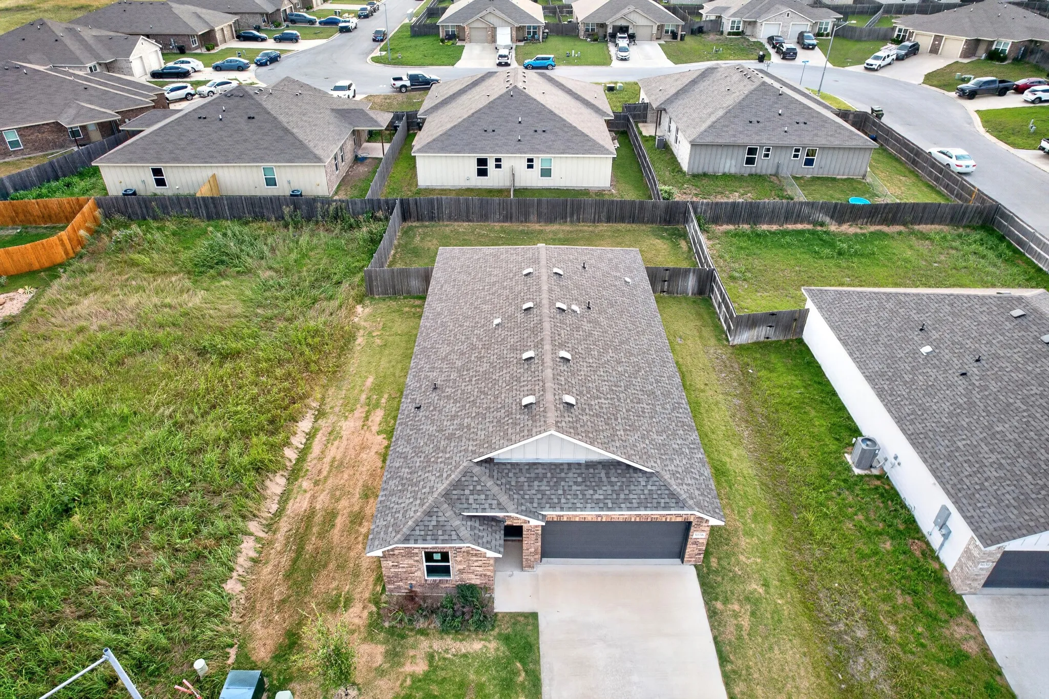 Brick and siding exterior with an attached two-car garage, concrete driveway, and shingle roof
