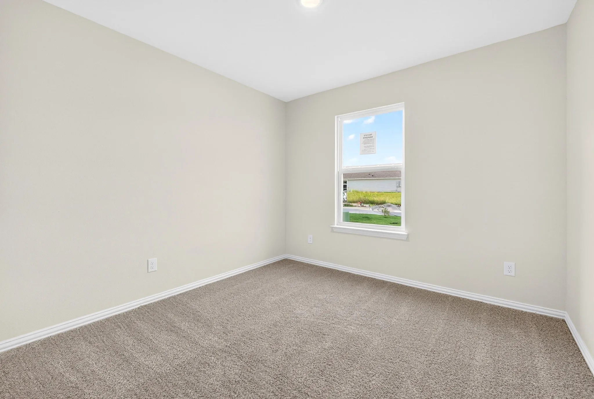 Neutral tone wall finishes, recessed ceiling lighting, light-toned carpet flooring, and a single window with white trim